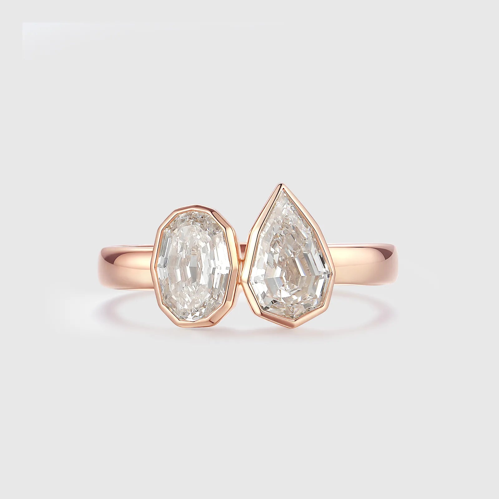 Step cut oval and pear cut diamond ring in rose gold