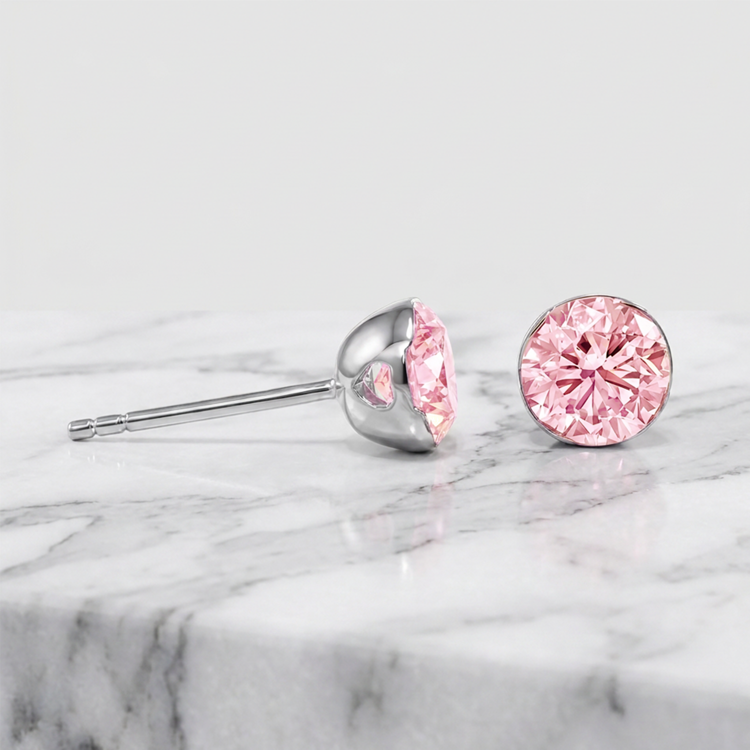 Round pink lab-grown diamond stud earrings shown from the front and side in white gold.