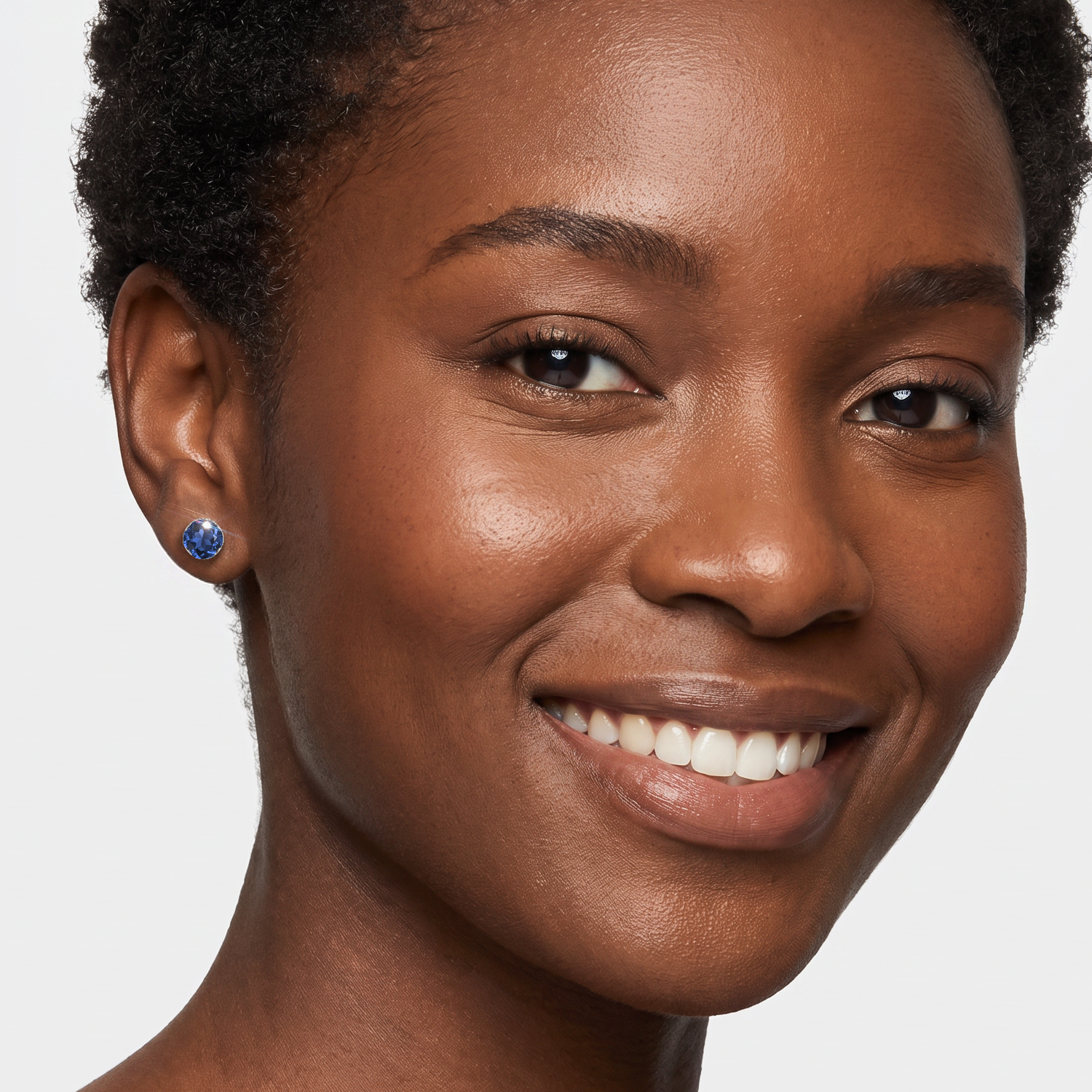 Round lab-grown sapphire stud earring in white gold worn by a model.