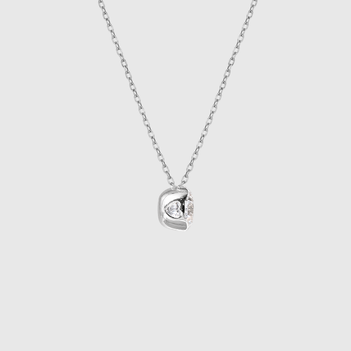 White gold round diamond solitaire necklace setting detail.