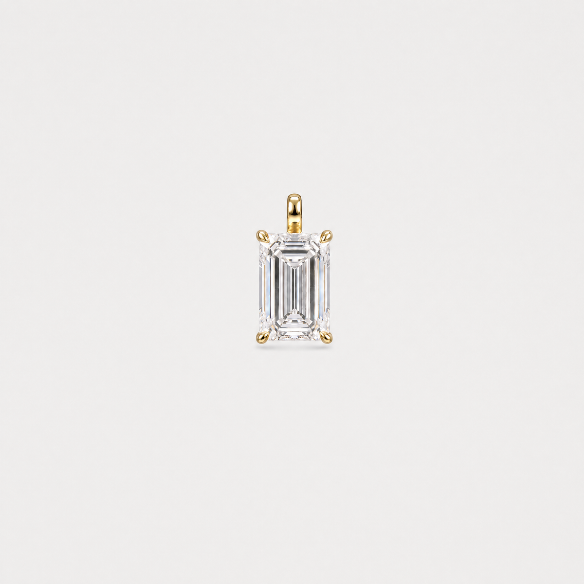Front view of an emerald-cut solitaire pendant in yellow gold with a four-prong setting.