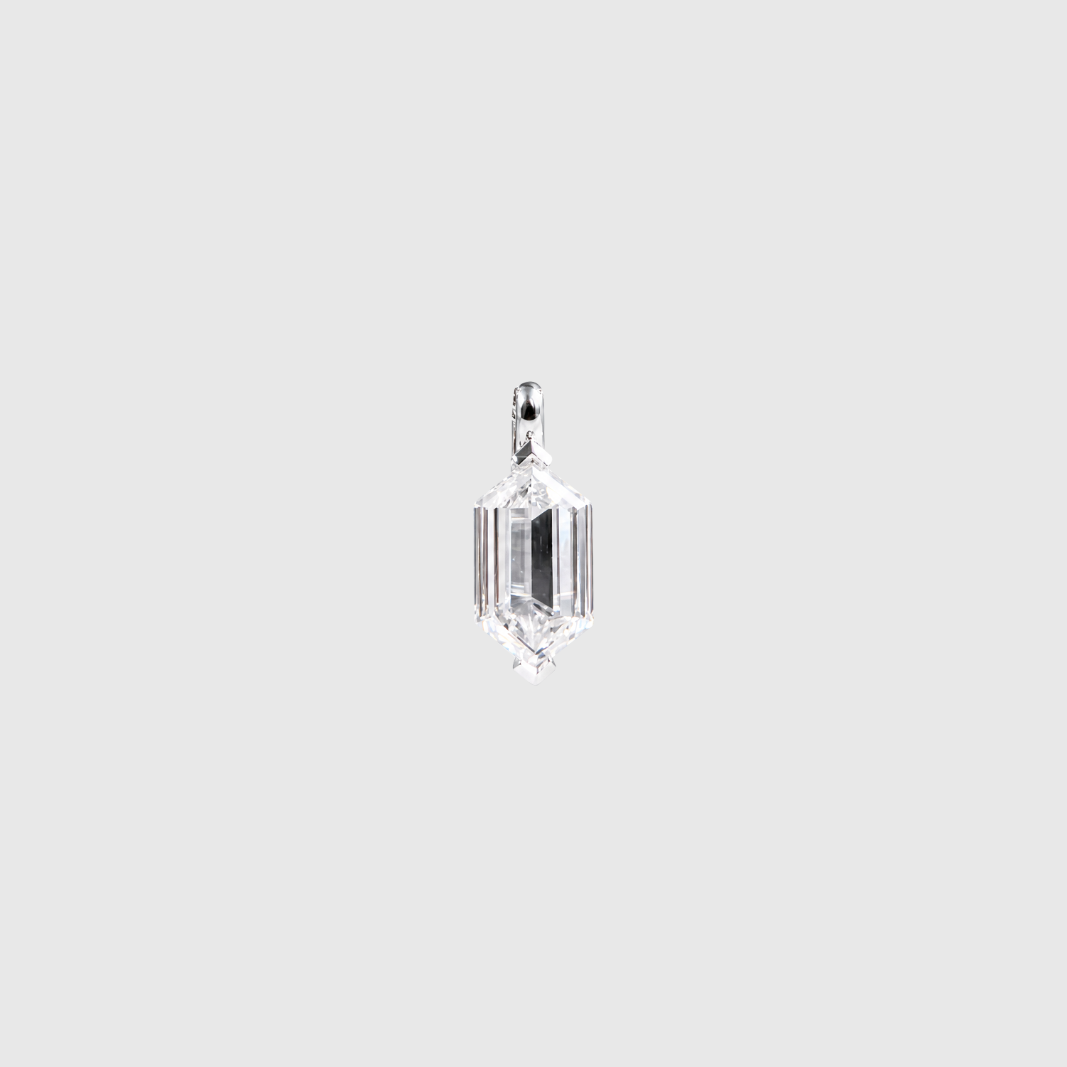 Front view of an elongated hexagon-cut diamond pendant in white metal on a light background.