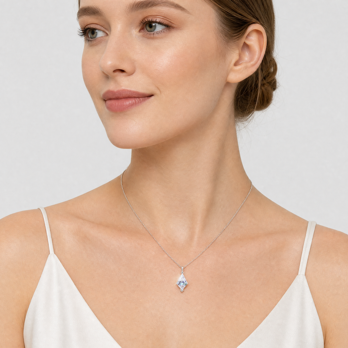White-gold kite-cut pendant worn on a fine chain against a white background.