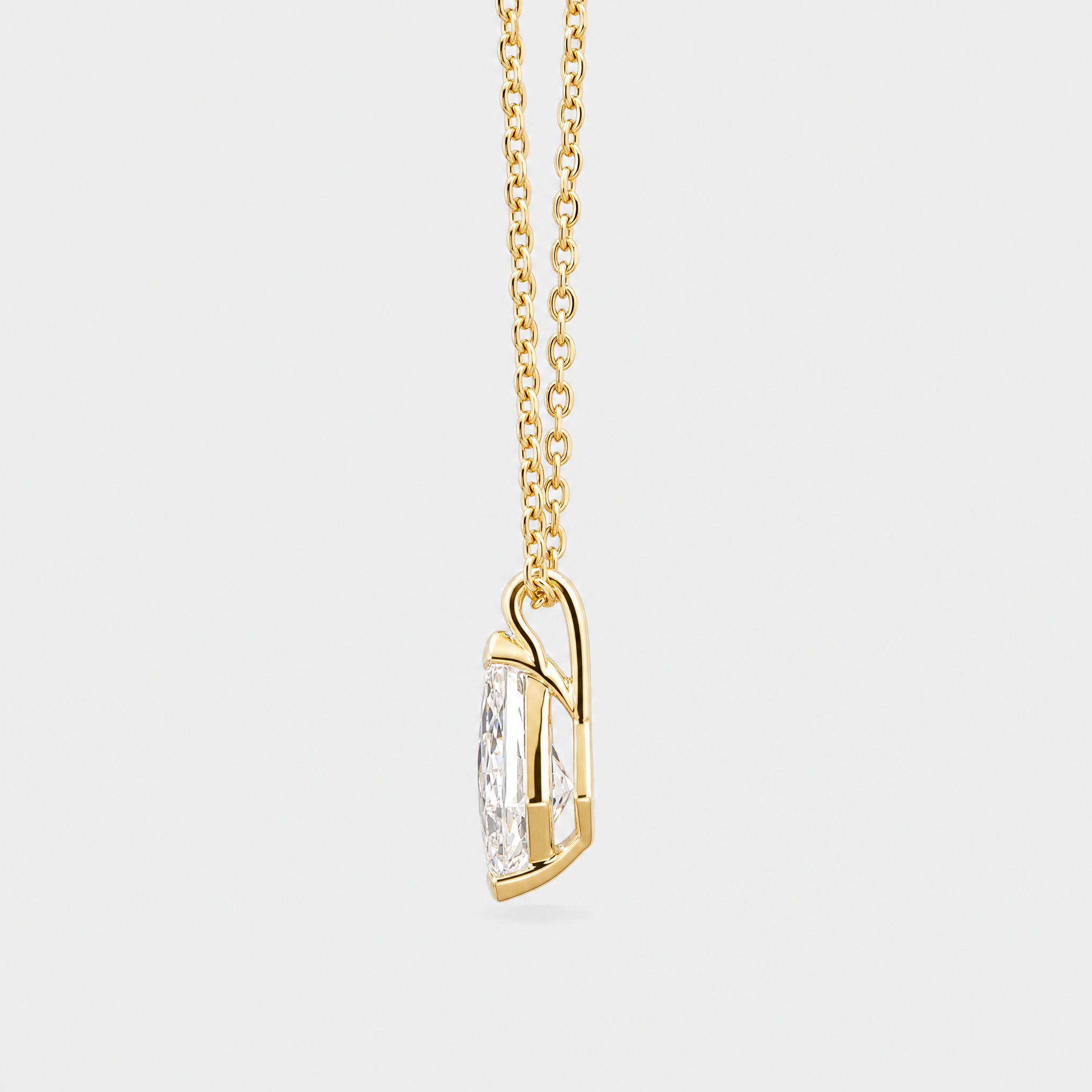 Side view of a kite-cut solitaire pendant in yellow gold displayed on a matching chain.