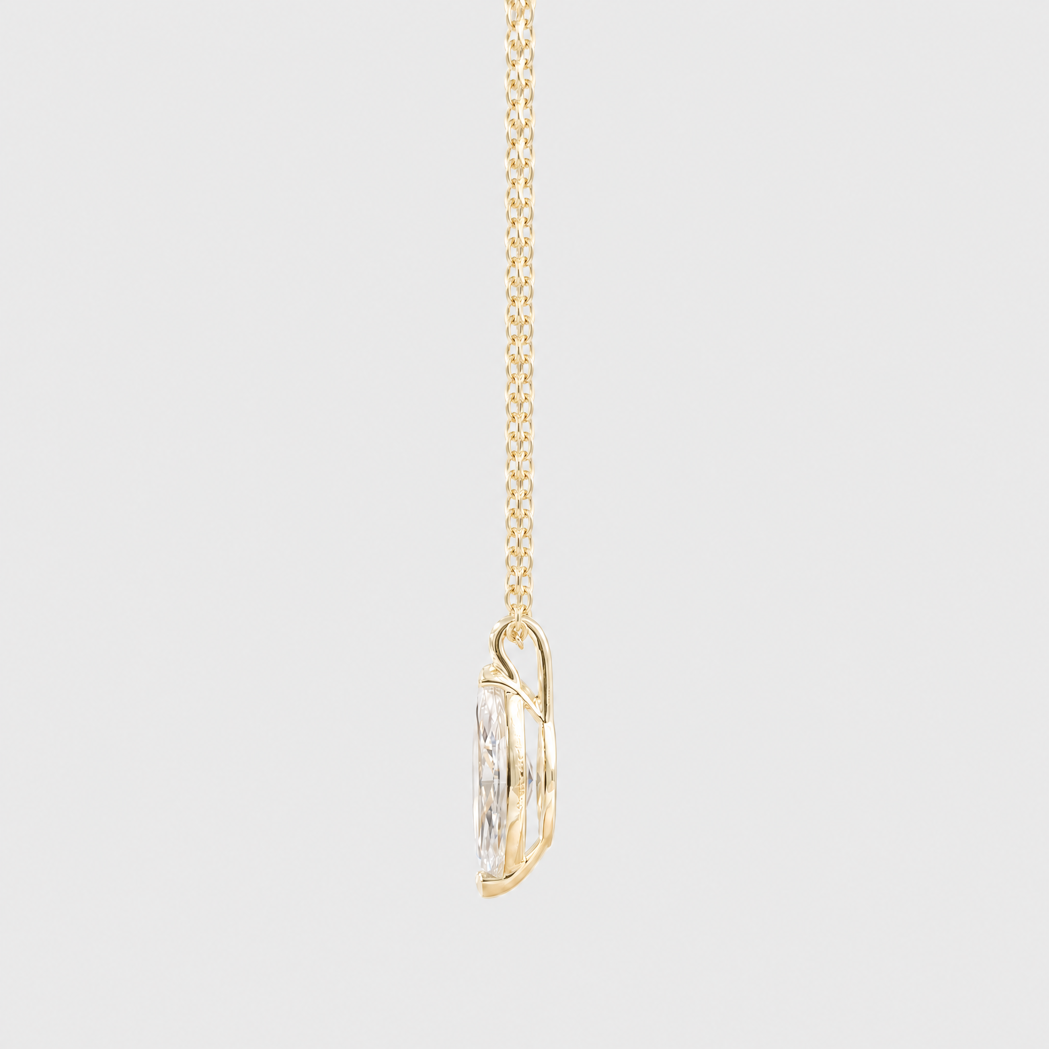 Side view of a marquise-cut solitaire pendant in yellow gold displayed on a matching chain.