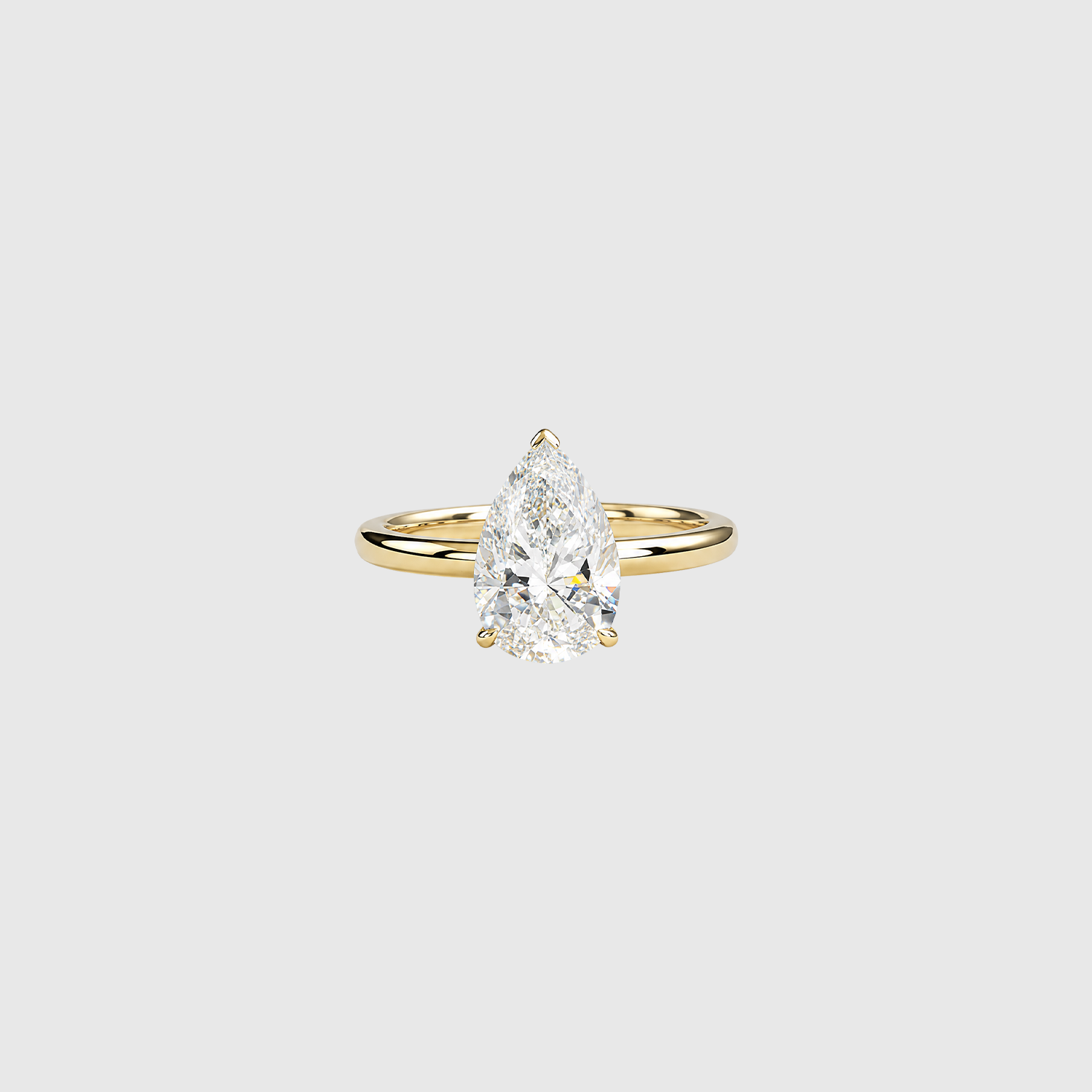 Pear-shaped lab-grown diamond solitaire engagement ring in yellow gold, front view.