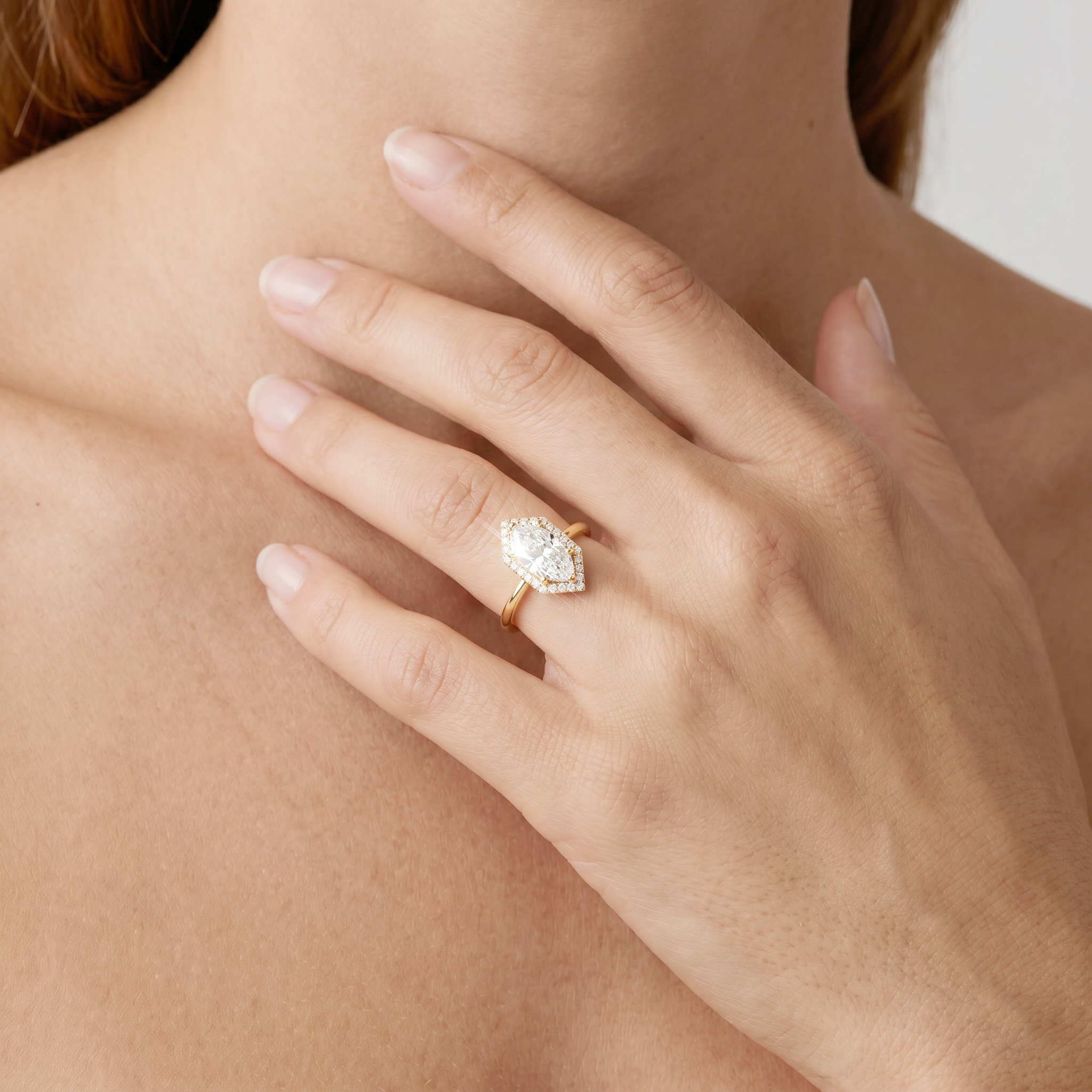 Hand wearing a halo hexagon diamond ring on a blurred background