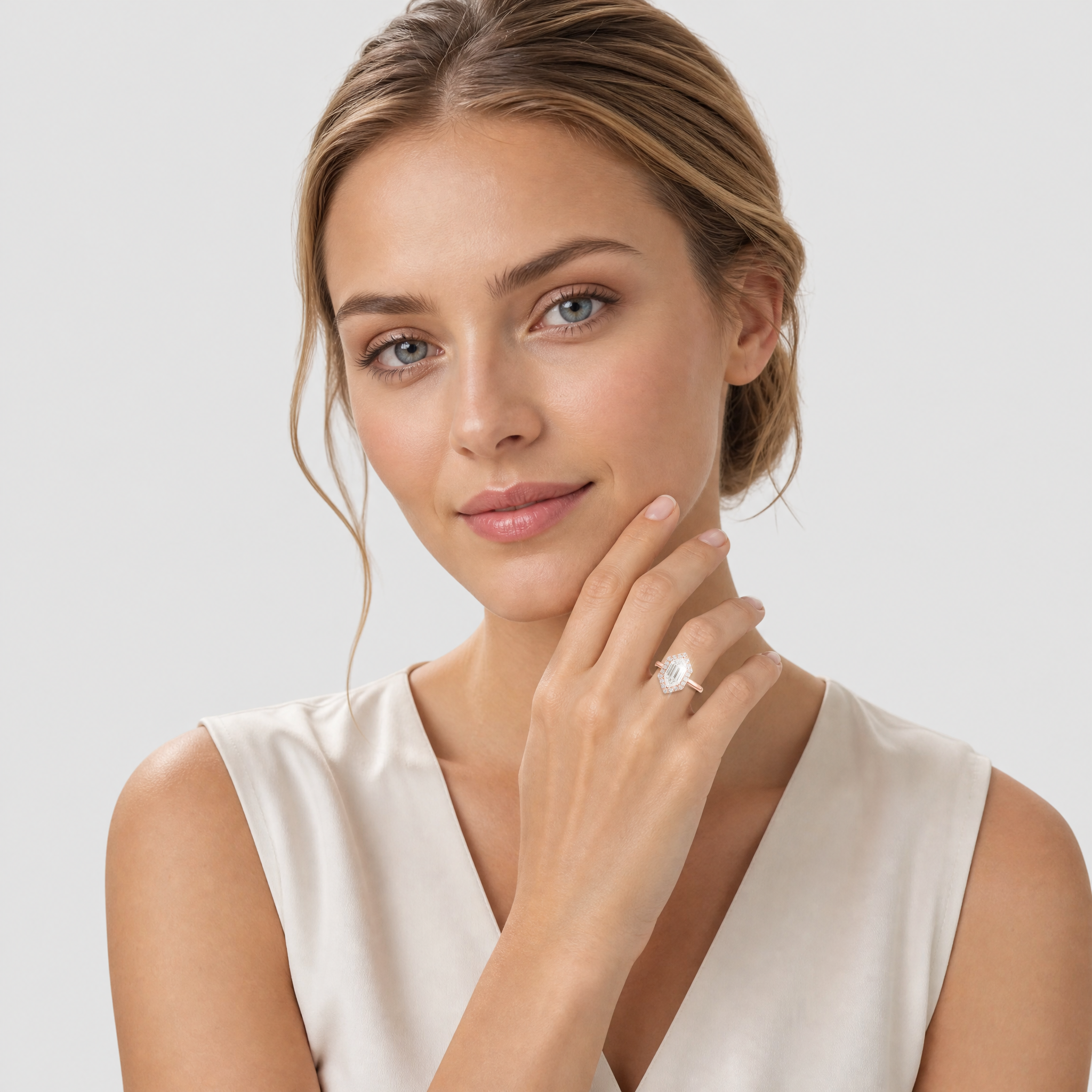 Woman wearing a halo hexagon diamond ring on a plain background