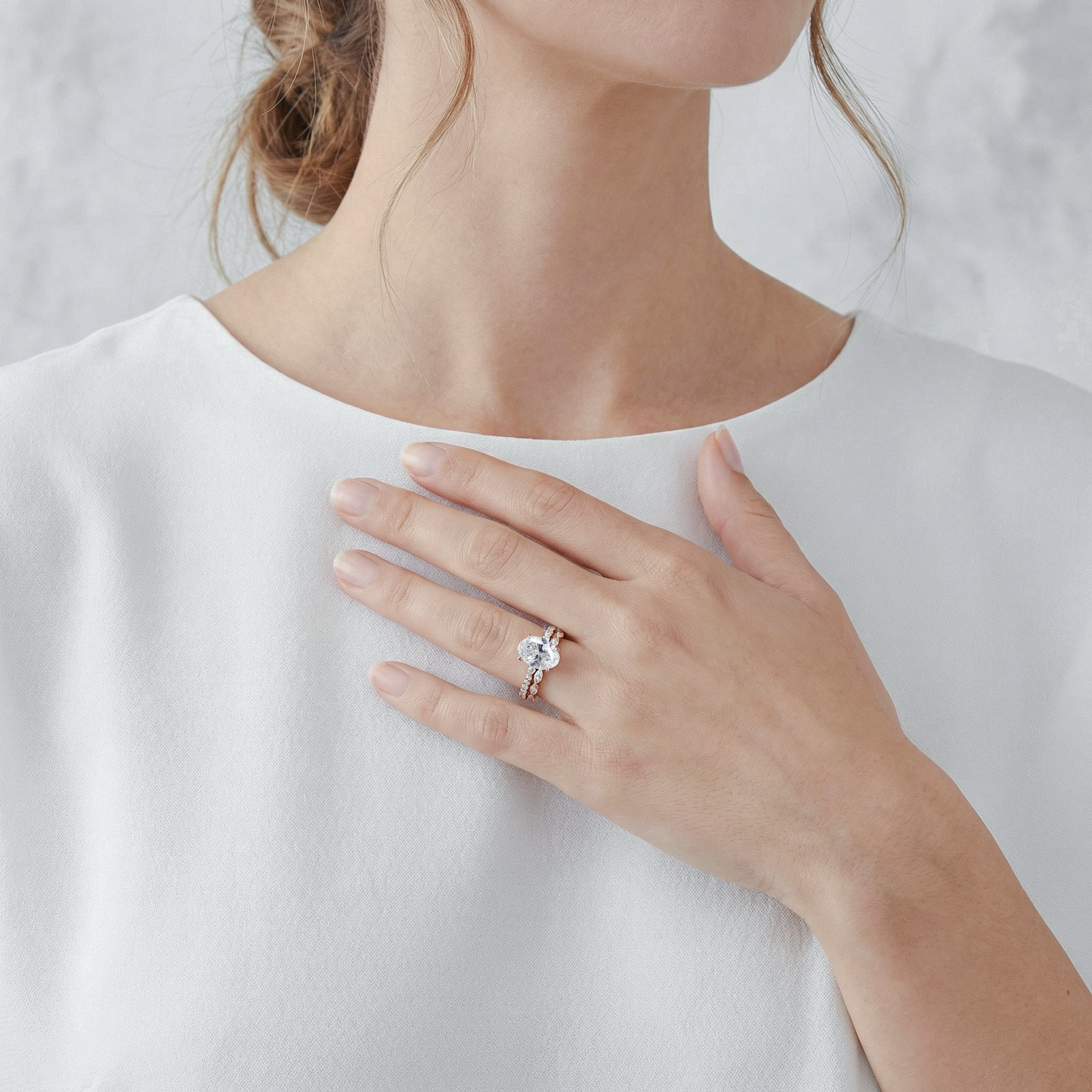Close-up of a person wearing oval diamond ring set