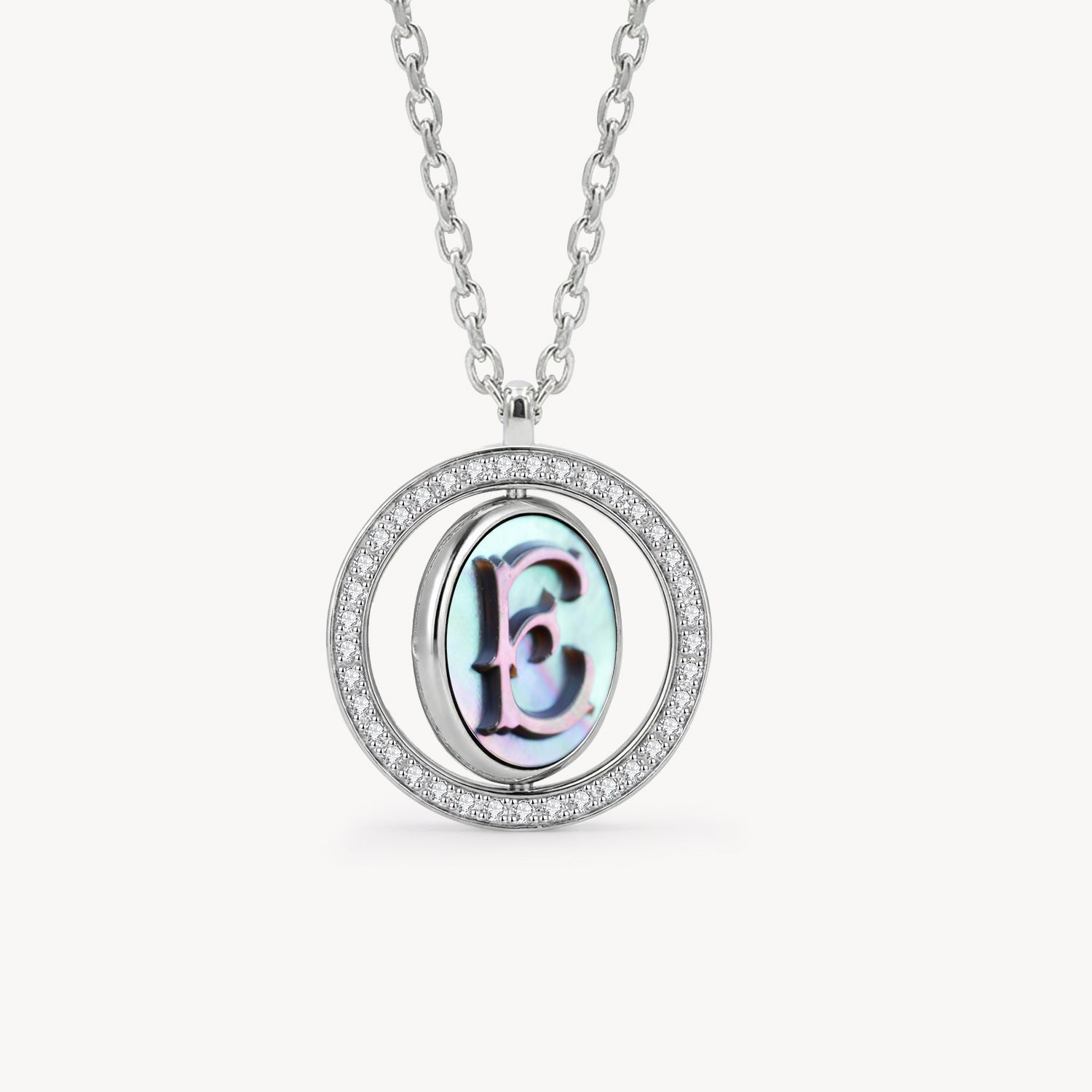 Reversible personalized initial diamond necklace with a black mother-of-pearl background, shown on a 925 sterling silver chain.