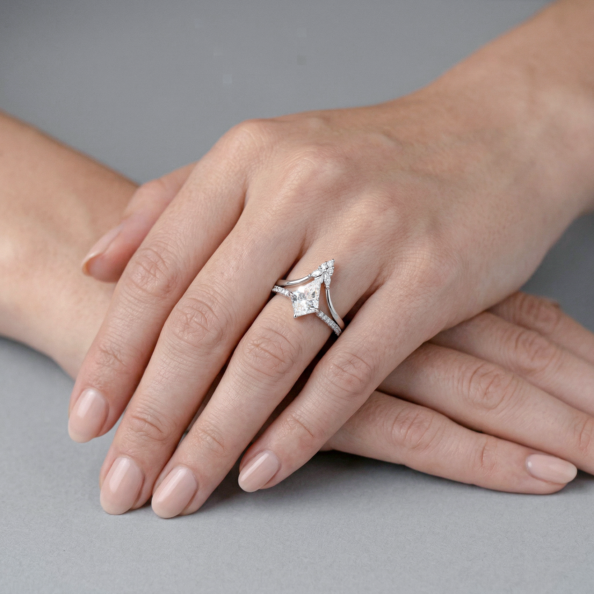 Kite Diamond white gold ring set on a person's finger against a neutral background
