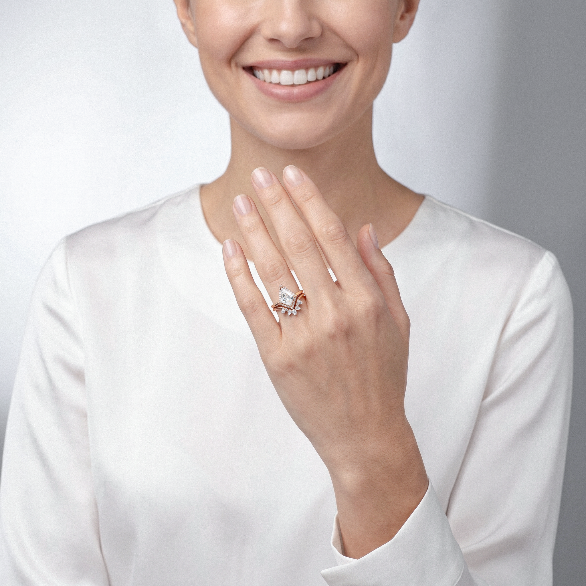 Woman wearing rose gold kite cut diamond ring set on her finger against a plain background