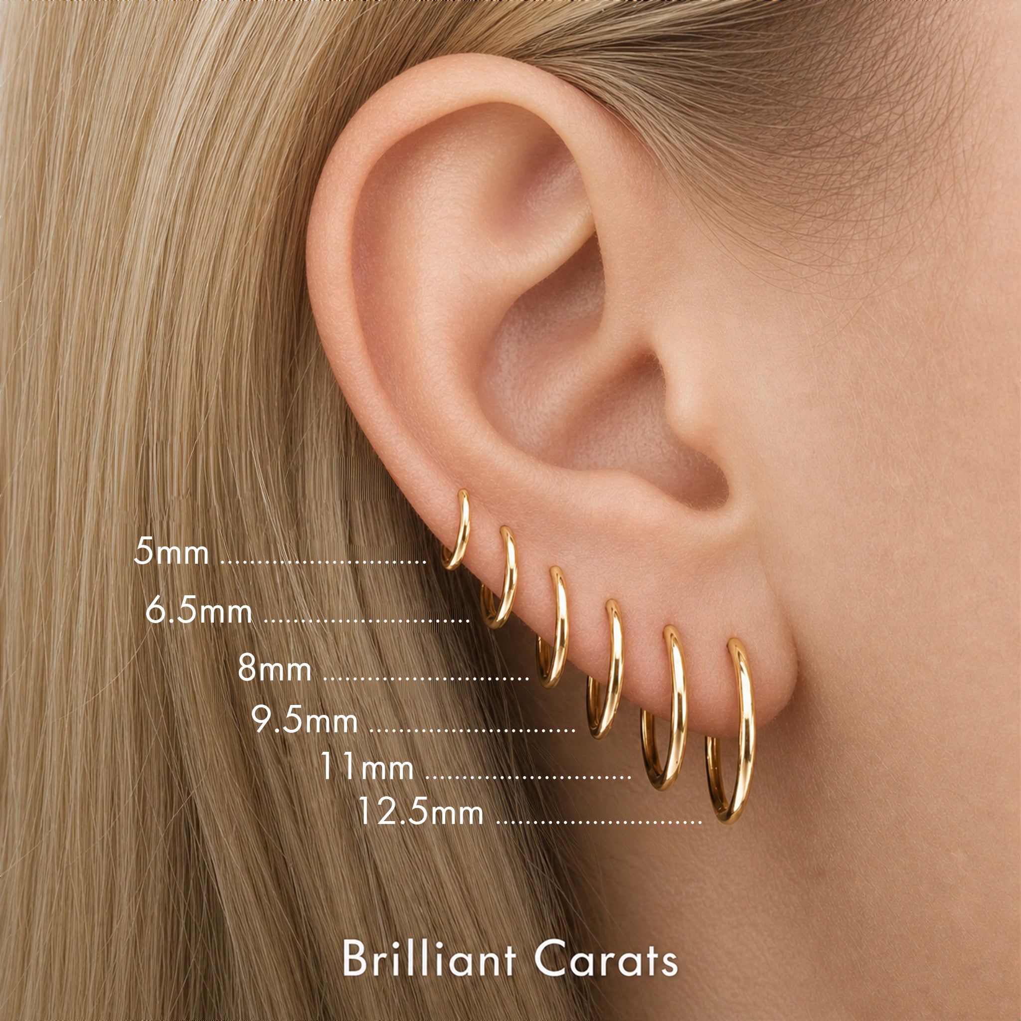 Close-up of a person's ear wearing multiple gold hoop earrings at different sizes, with size labels in millimeters of Brilliant Carats