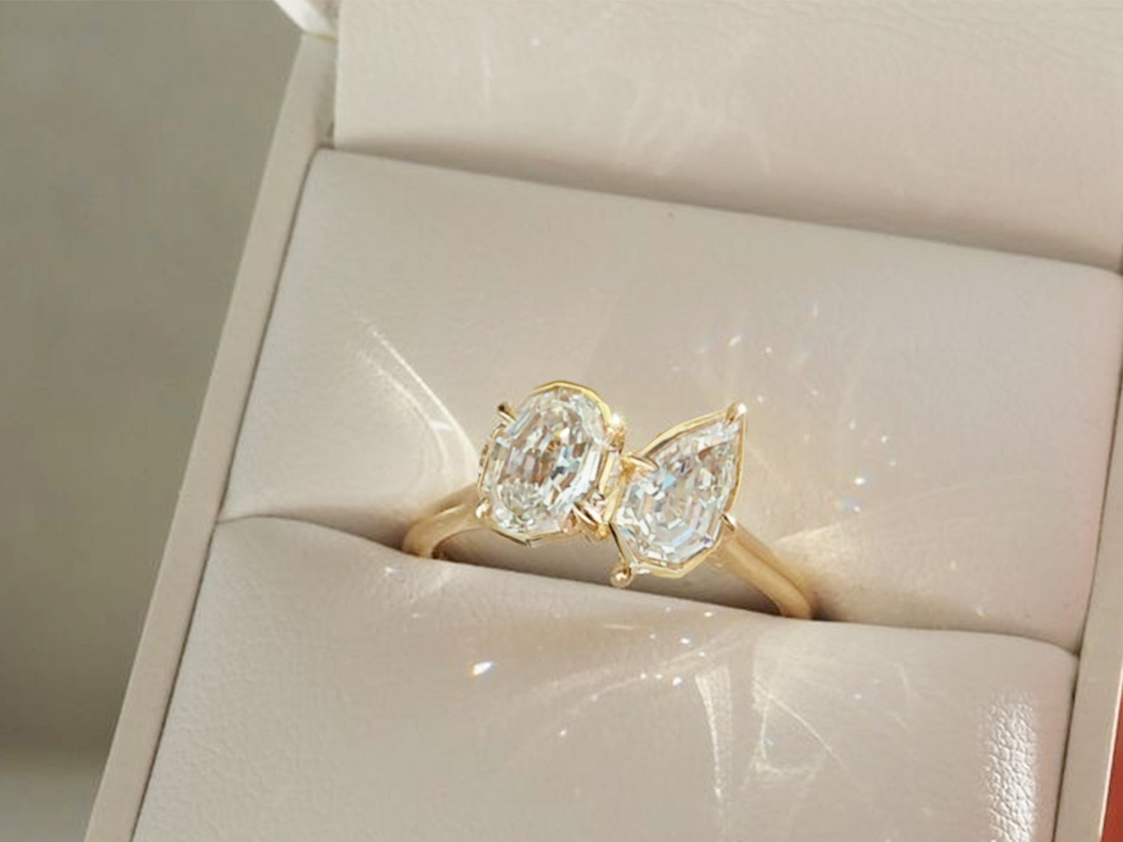 Elegant gold moissanite engagement ring featuring two brilliant stones in a modern design