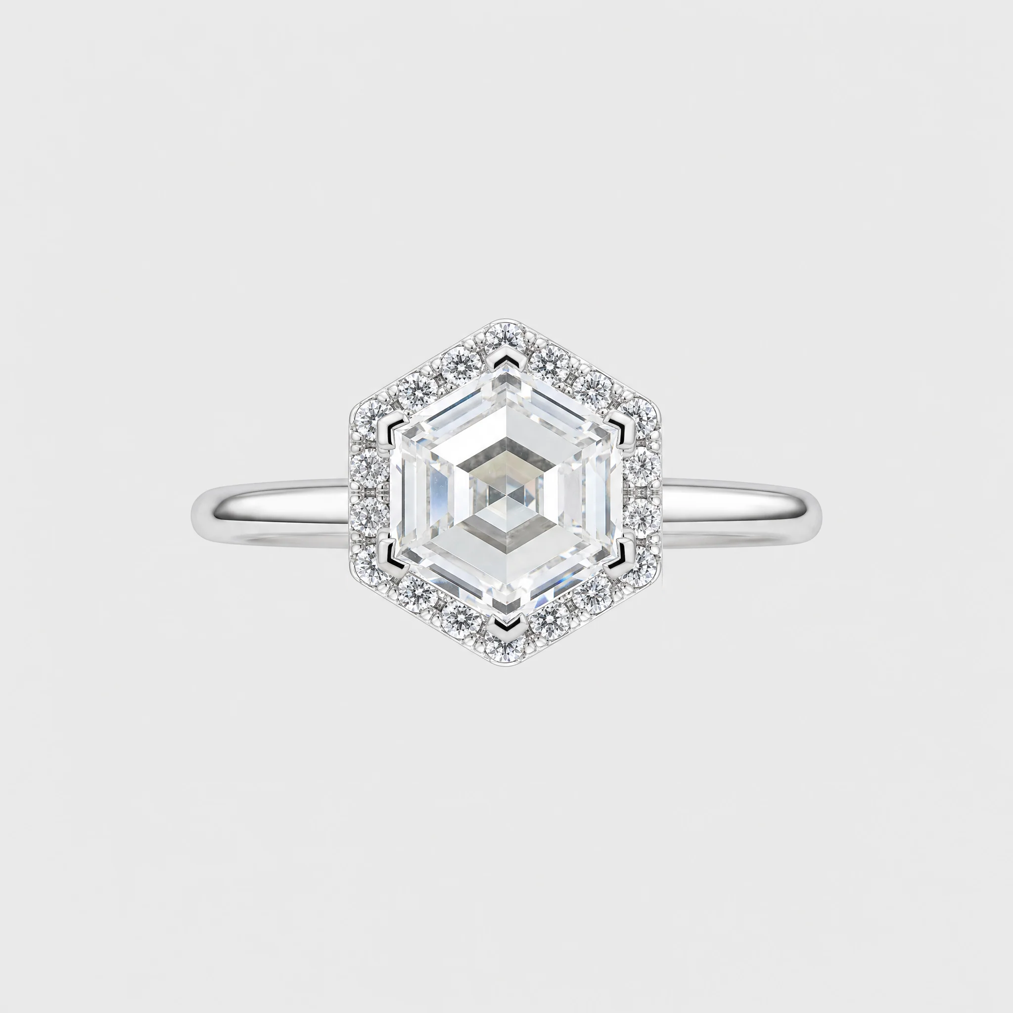 A wihte gold hexagonal halo ring featuring a large central clear gemstone surrounded by smaller accent stones, set against a light gray background.