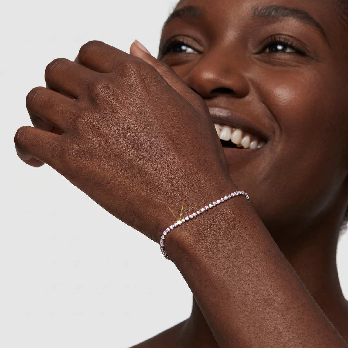 Model wearing a white gold tennis bracelet set with alternating white and pink lab-grown diamonds.