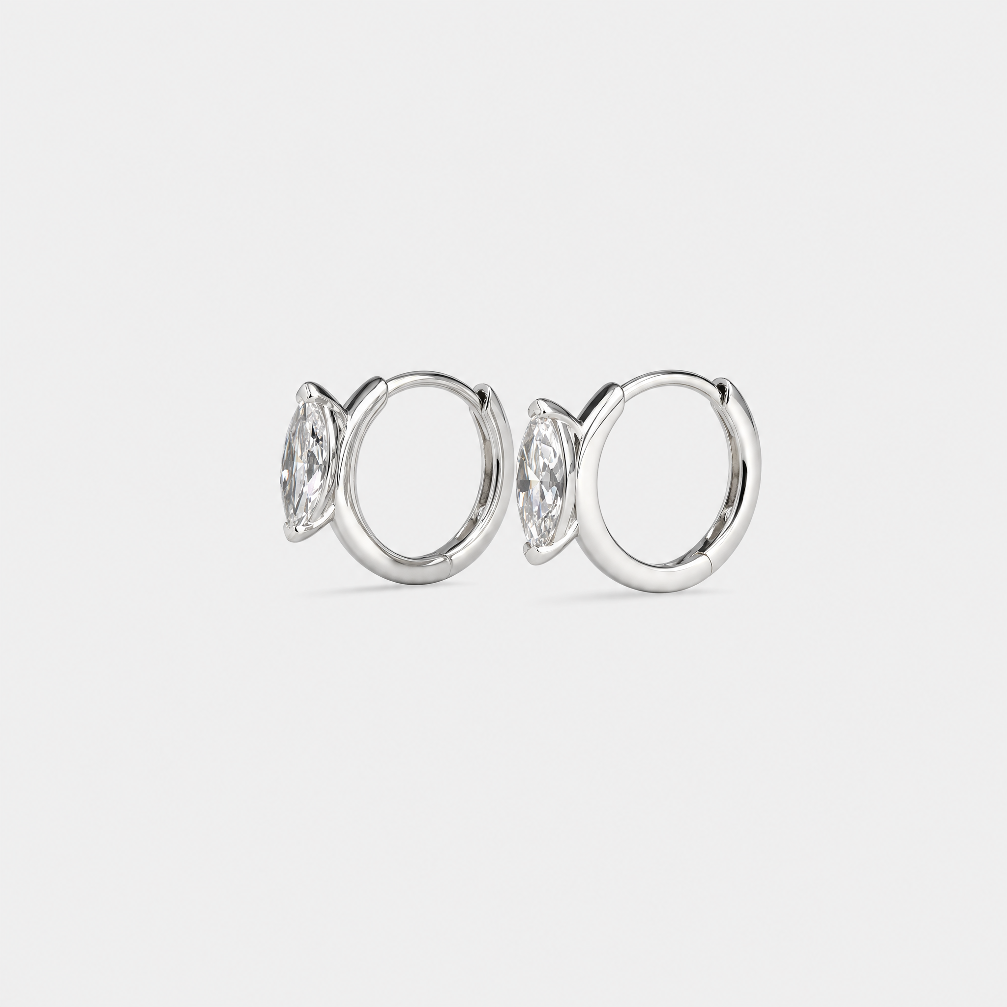 Side view of marquise-cut hoop earrings in white gold showing the hinged hoops and stone settings.
