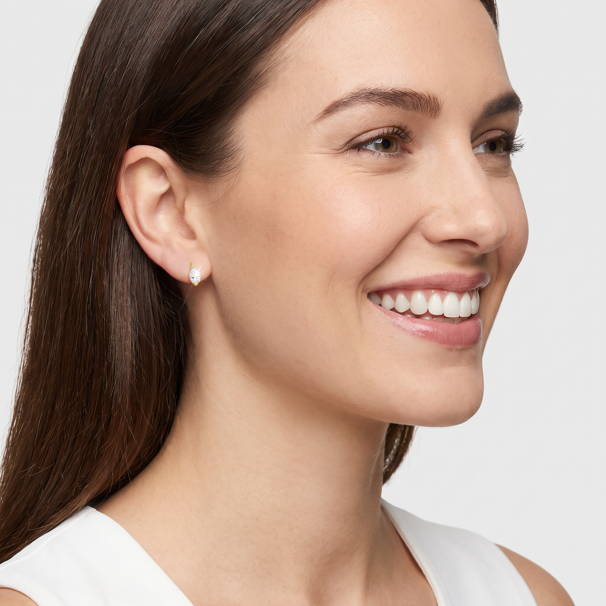Yellow-gold pear-shaped hoop earring worn on an ear in a model view.