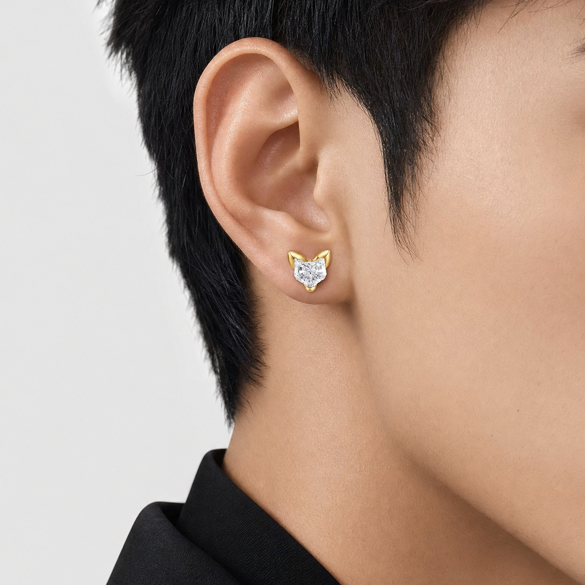 cat-shaped diamond earring worn by a man with a neutral background
