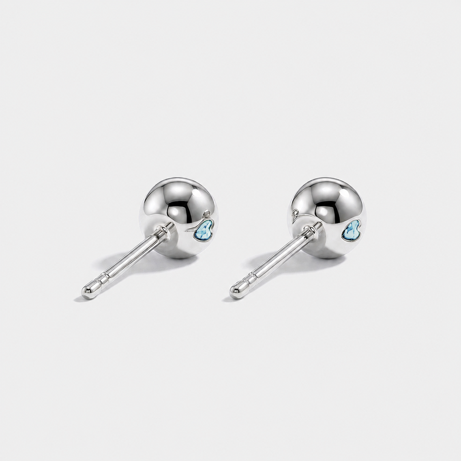 Back view of round lab-grown aquamarine stud earrings with white gold settings and ball backs.
