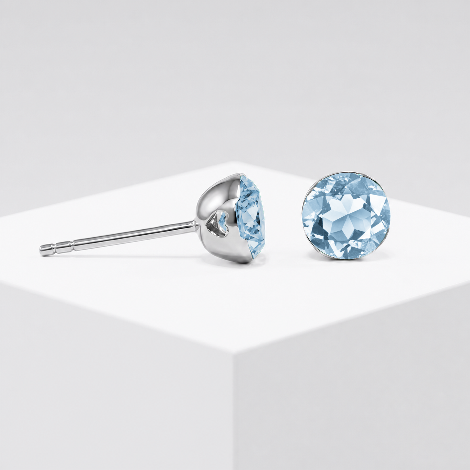 Round lab-grown aquamarine stud earrings shown from the front and side in white gold.