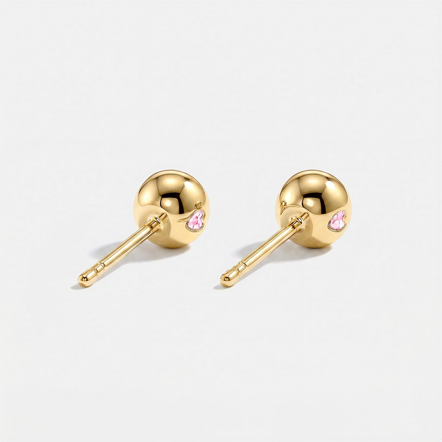 Back view of round pink lab-grown diamond stud earrings with yellow gold settings and ball backs.