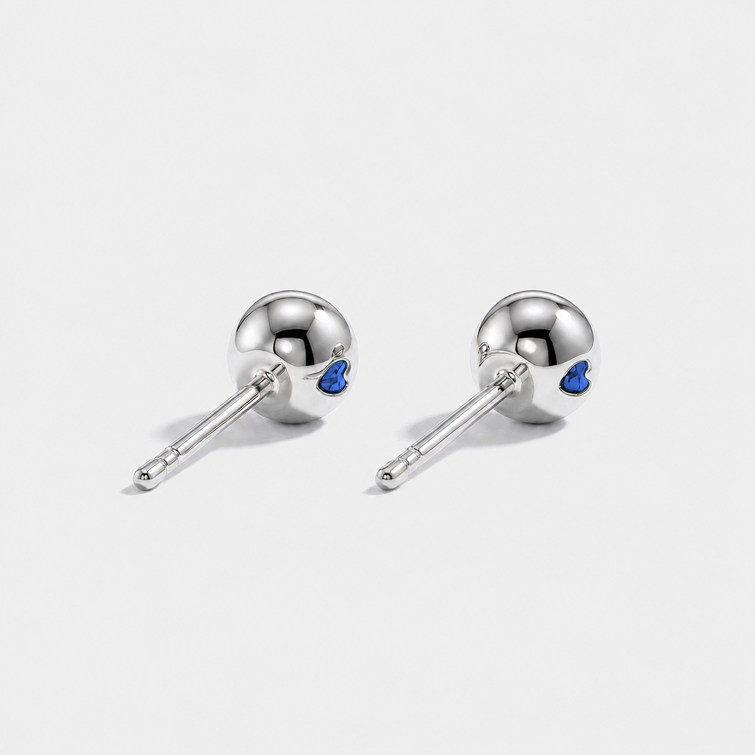 Back view of round lab-grown sapphire stud earrings with white gold settings and ball backs.