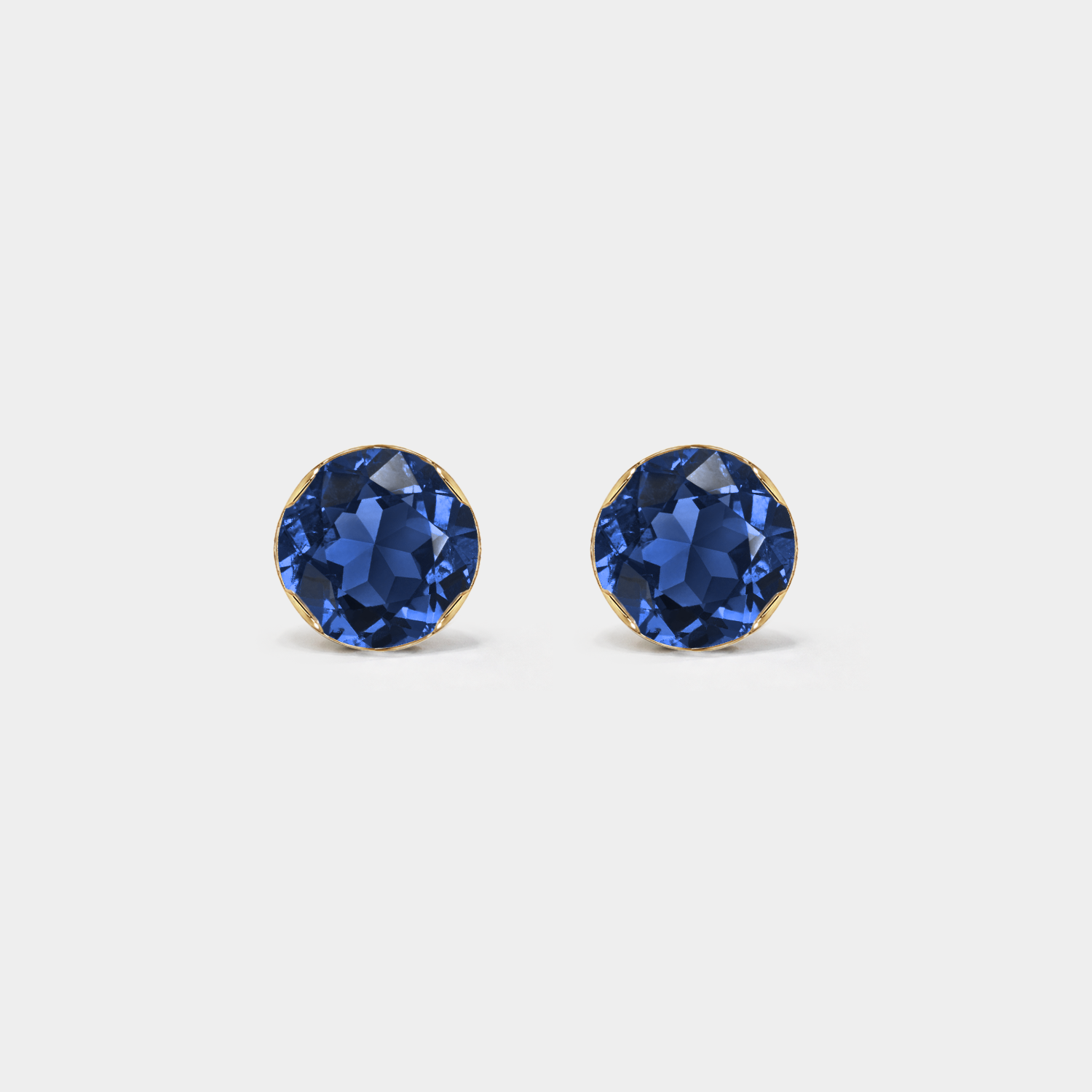 Front view of round lab-grown sapphire stud earrings in yellow gold on a white background.