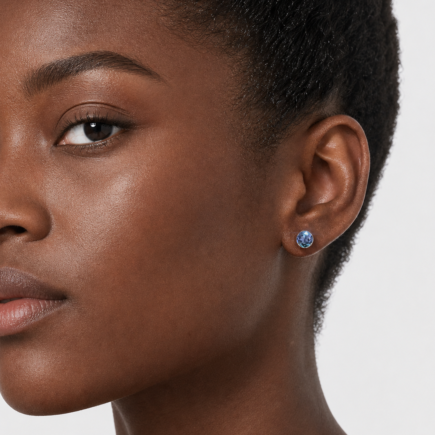 Round lab-grown alexandrite stud earring in white gold worn by a model.