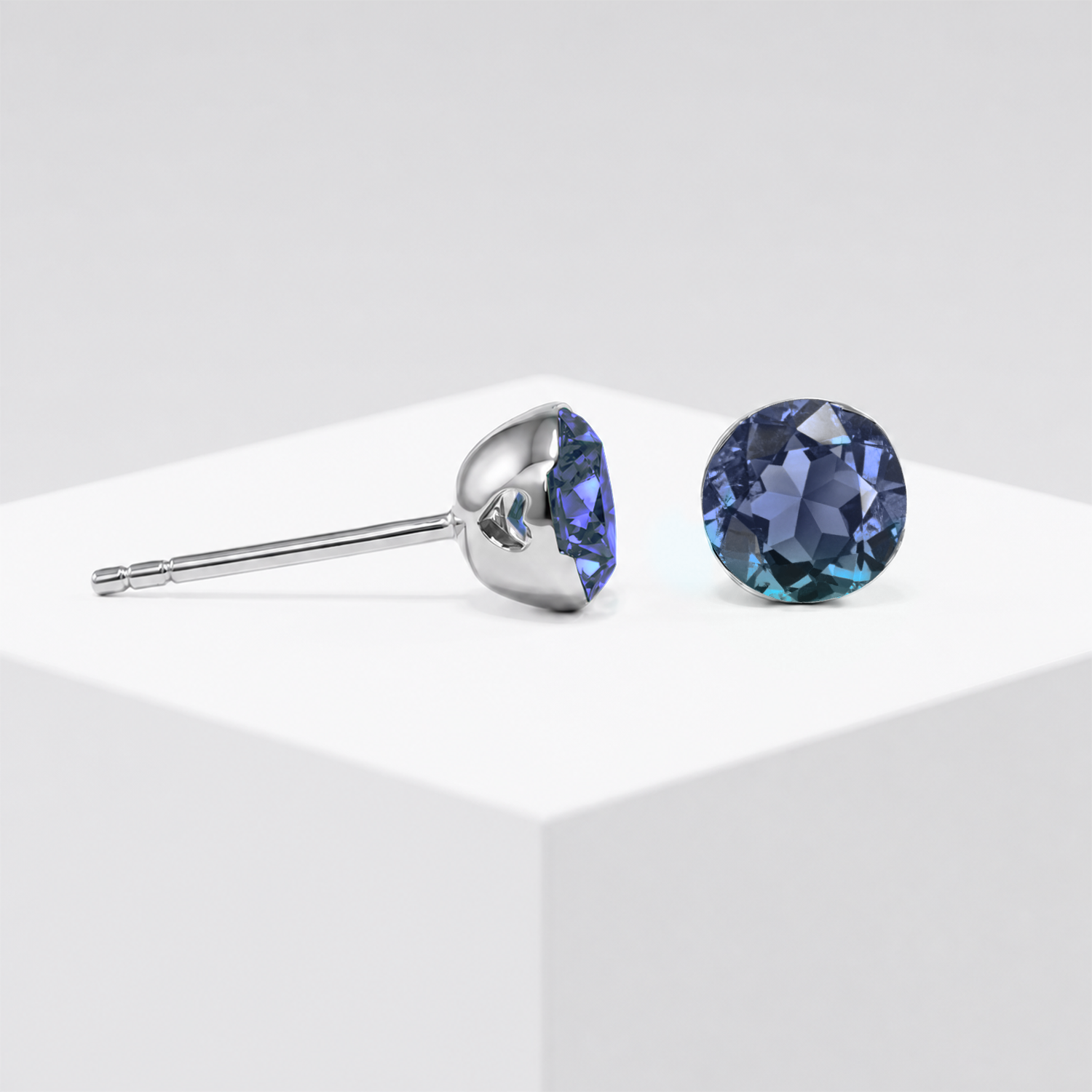 Round lab-grown alexandrite stud earrings shown from the front and side in white gold.