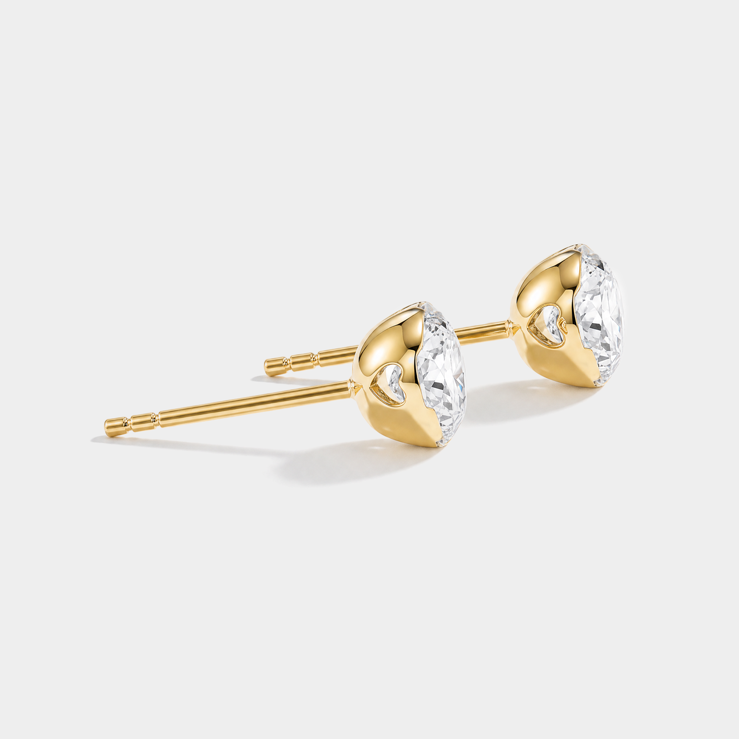 Round diamond stud earrings in yellow gold, side view
