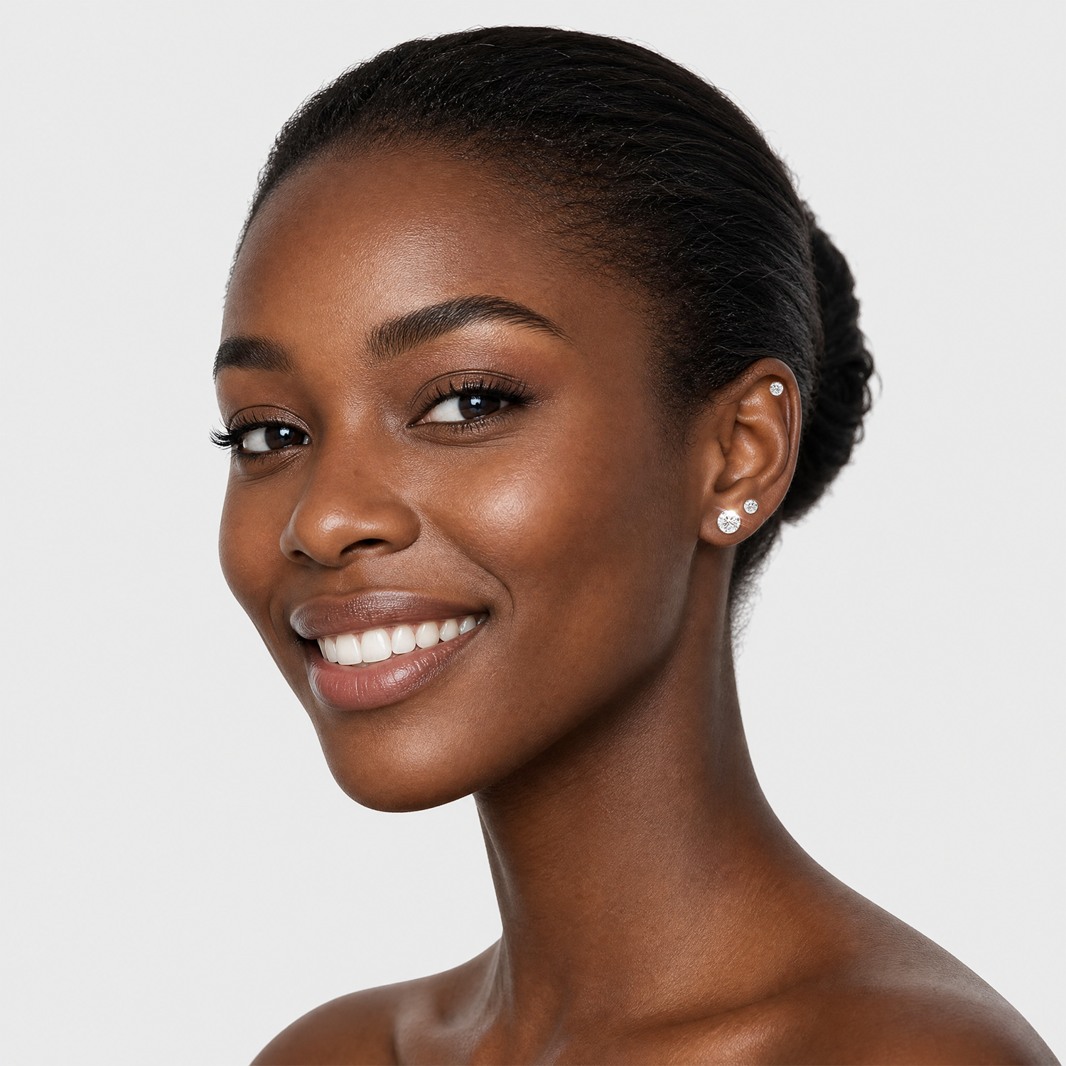 Round stone stud earrings in white metal worn on the ear