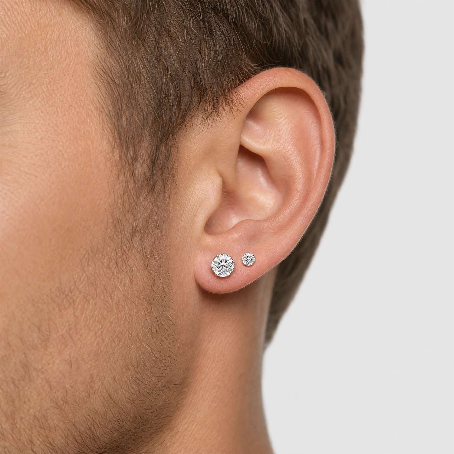 Round diamond  stud earrings in yellow gold worn in close-up