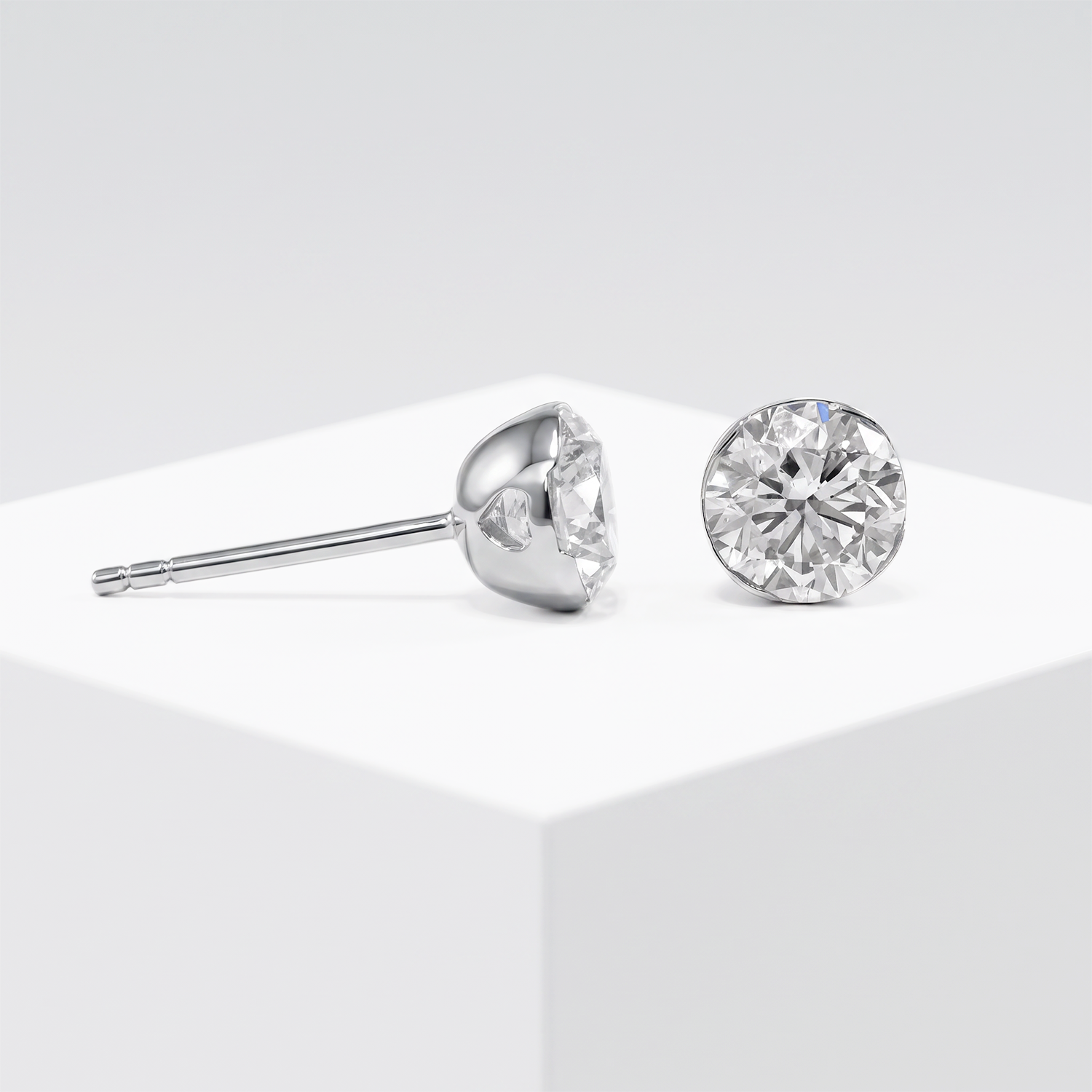 White metal round diamond stud earrings in a jewelry setting