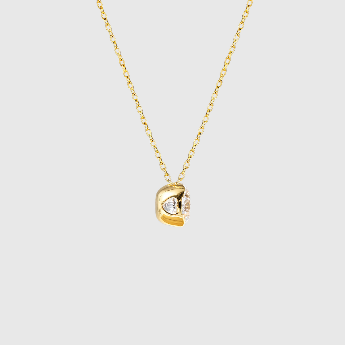 Yellow gold round diamond solitaire necklace setting detail.