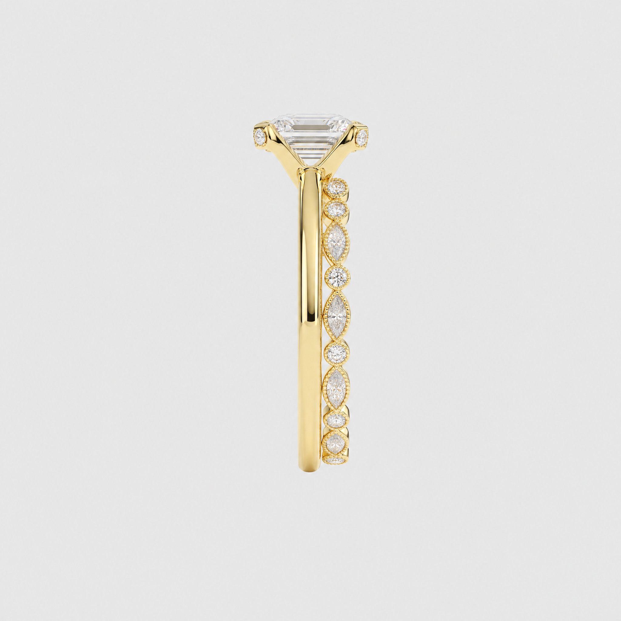 Side view of a yellow gold bridal set showing the emerald-cut center setting and marquise-and-round stone band.