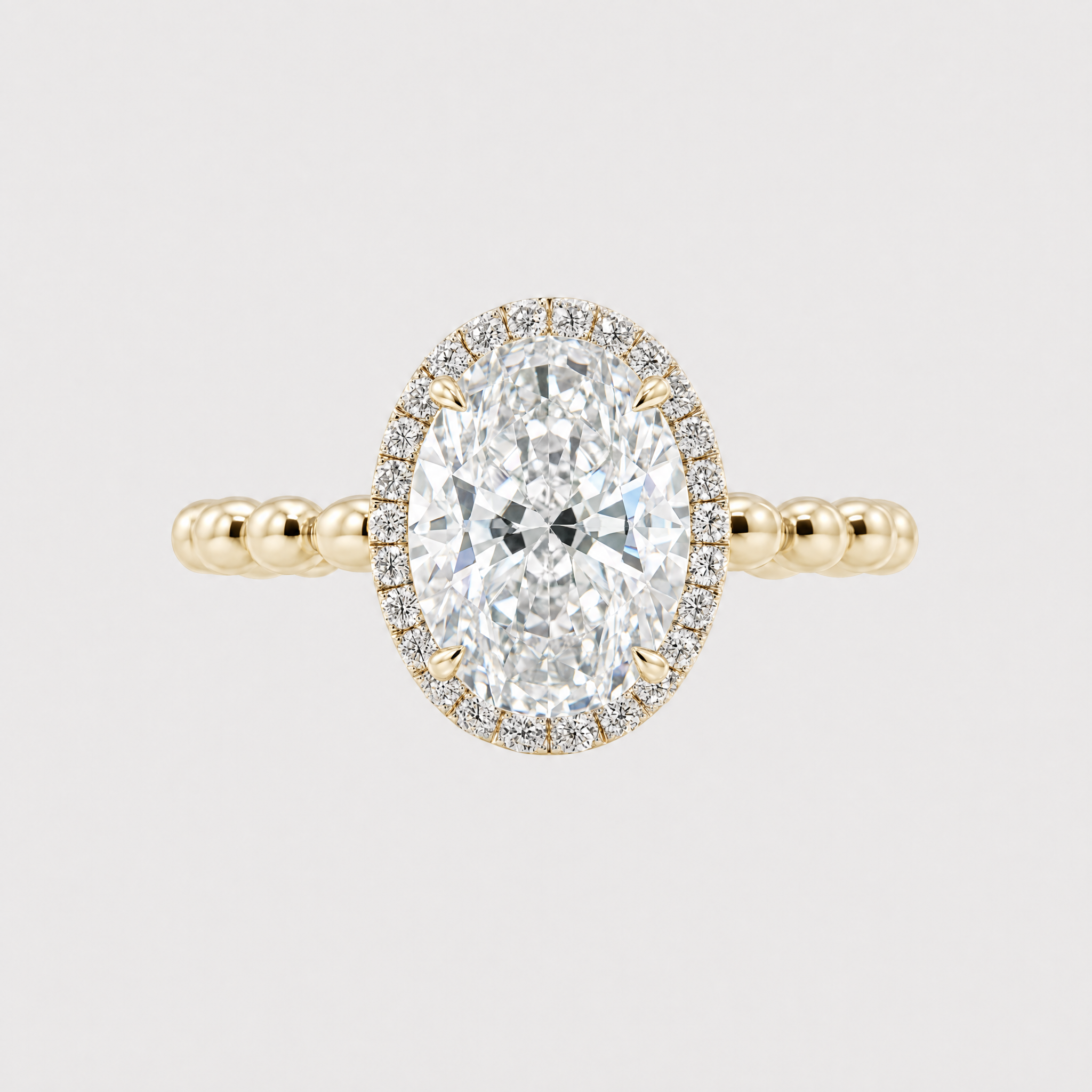 Gold halo oval diamond ring wih bubble band on a light gray background