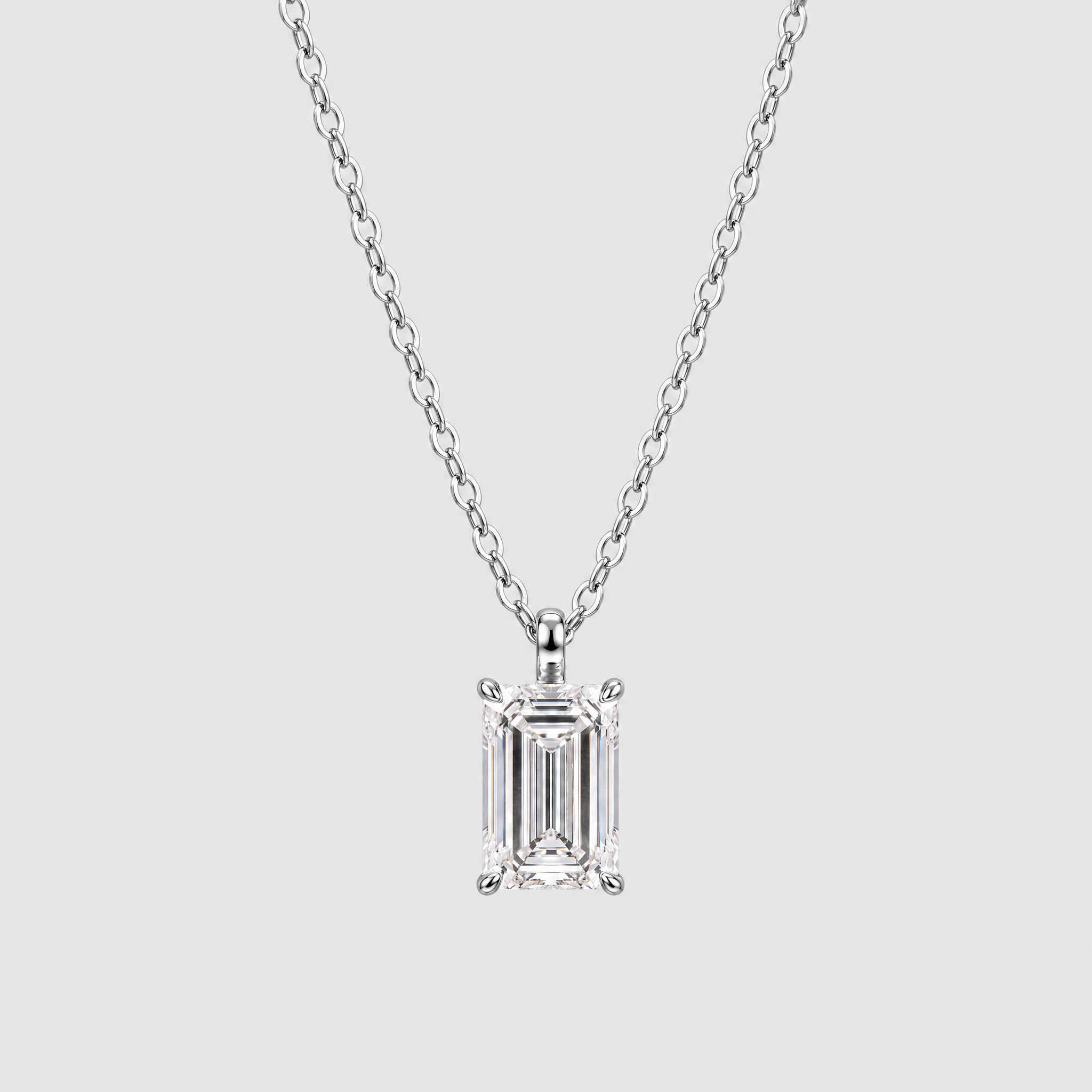 Emerald-cut solitaire pendant in white metal displayed on a matching chain.