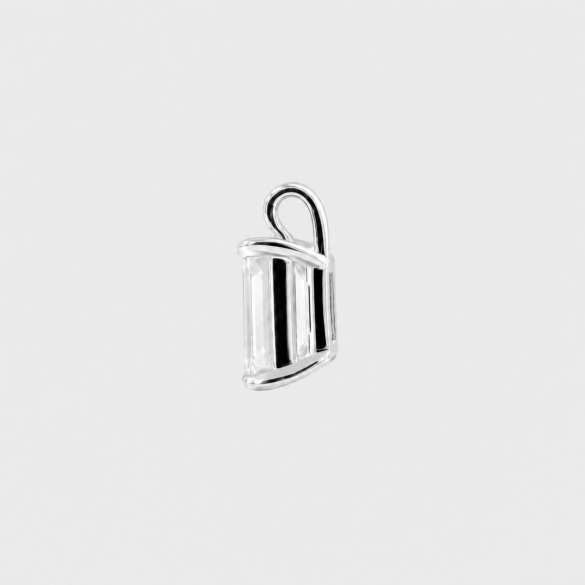 Side view of an emerald-cut solitaire pendant in white metal showing the open setting and bail.