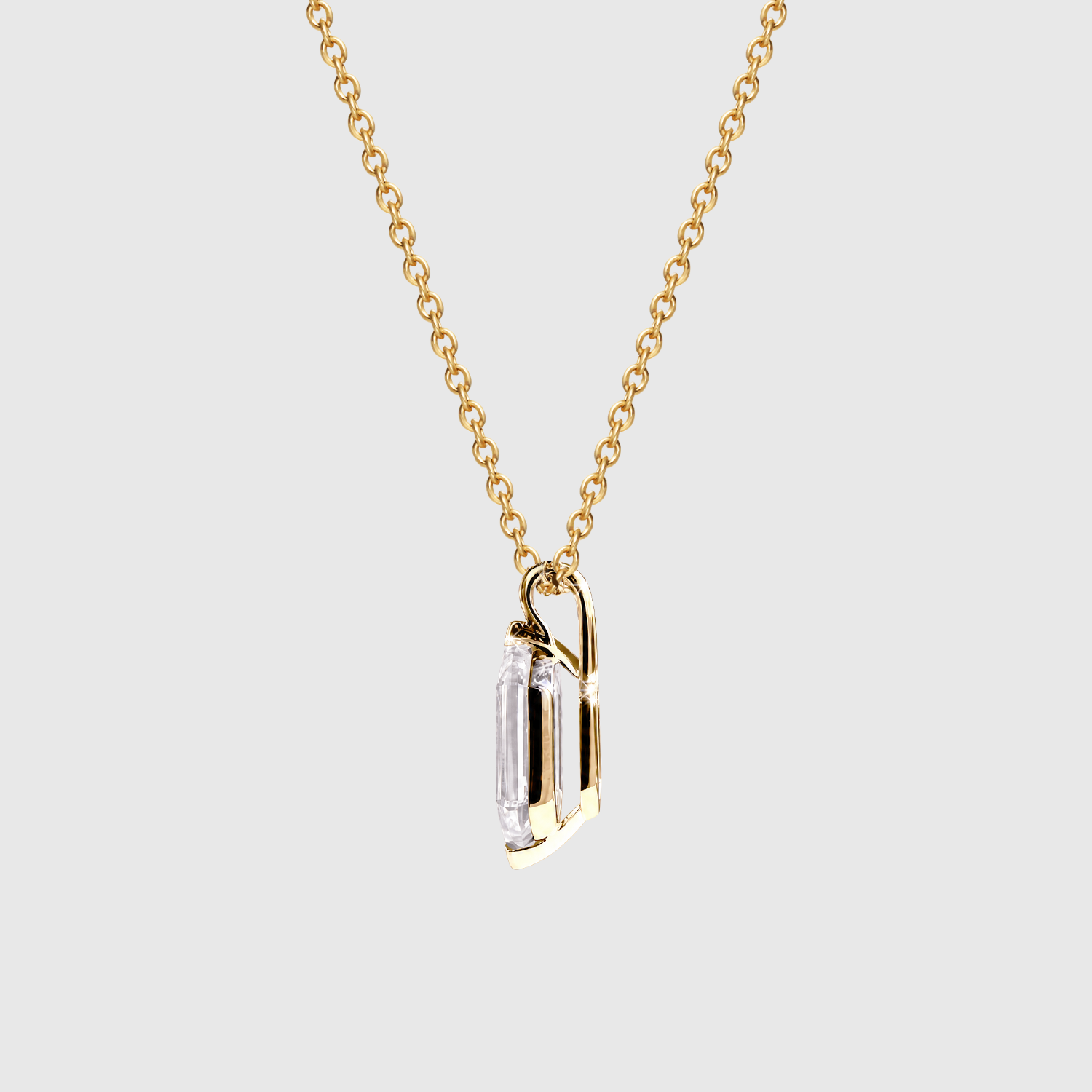 Side profile of an elongated hexagon-cut diamond pendant in yellow metal showing the open setting and bail.