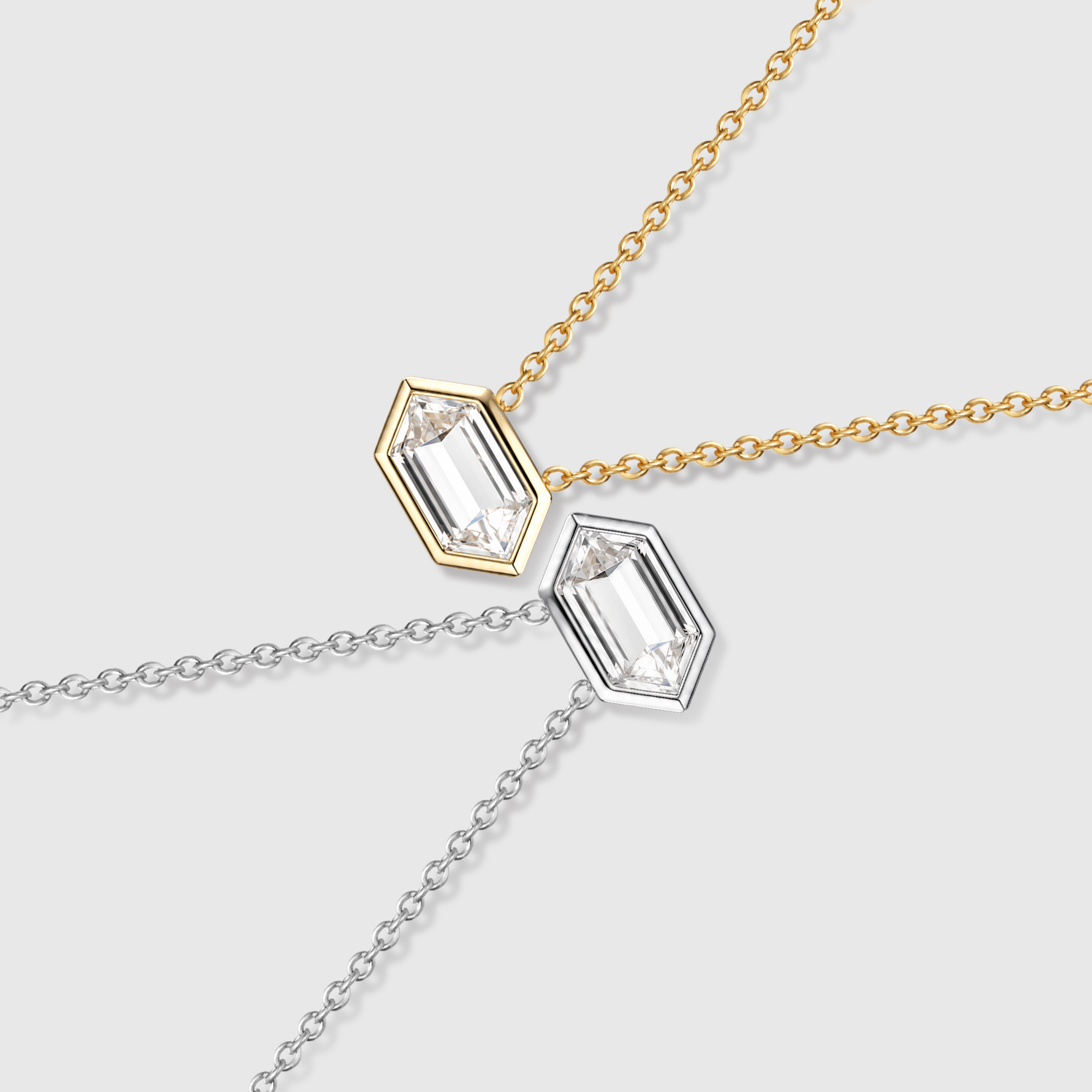 Elongated hexagon-cut diamond pendants in yellow and white gold displayed on fine chains.