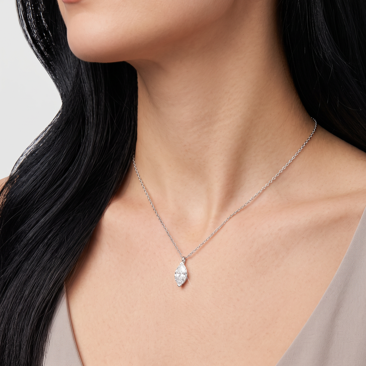 White-gold marquise-cut pendant worn on a fine chain against a light background.