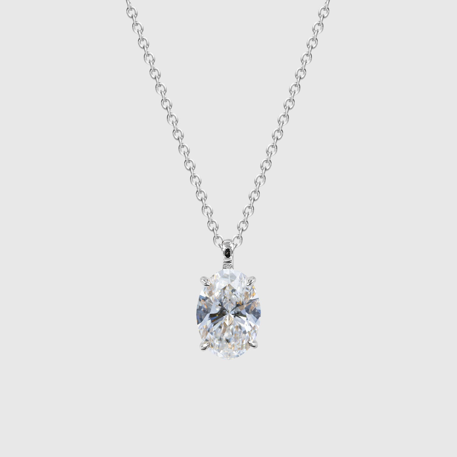 White gold oval diamond pendant displayed on a chain.