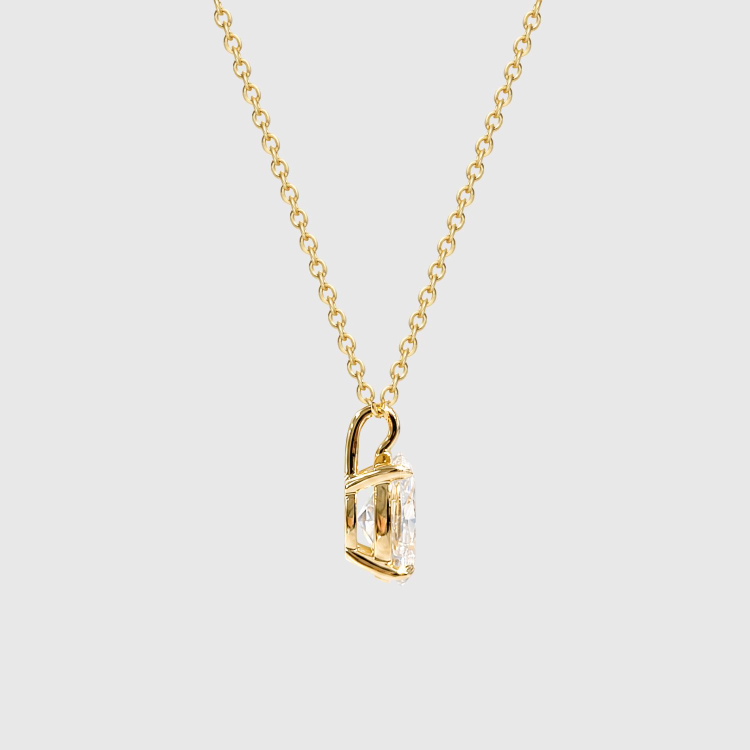 Yellow gold oval diamond pendant side view.