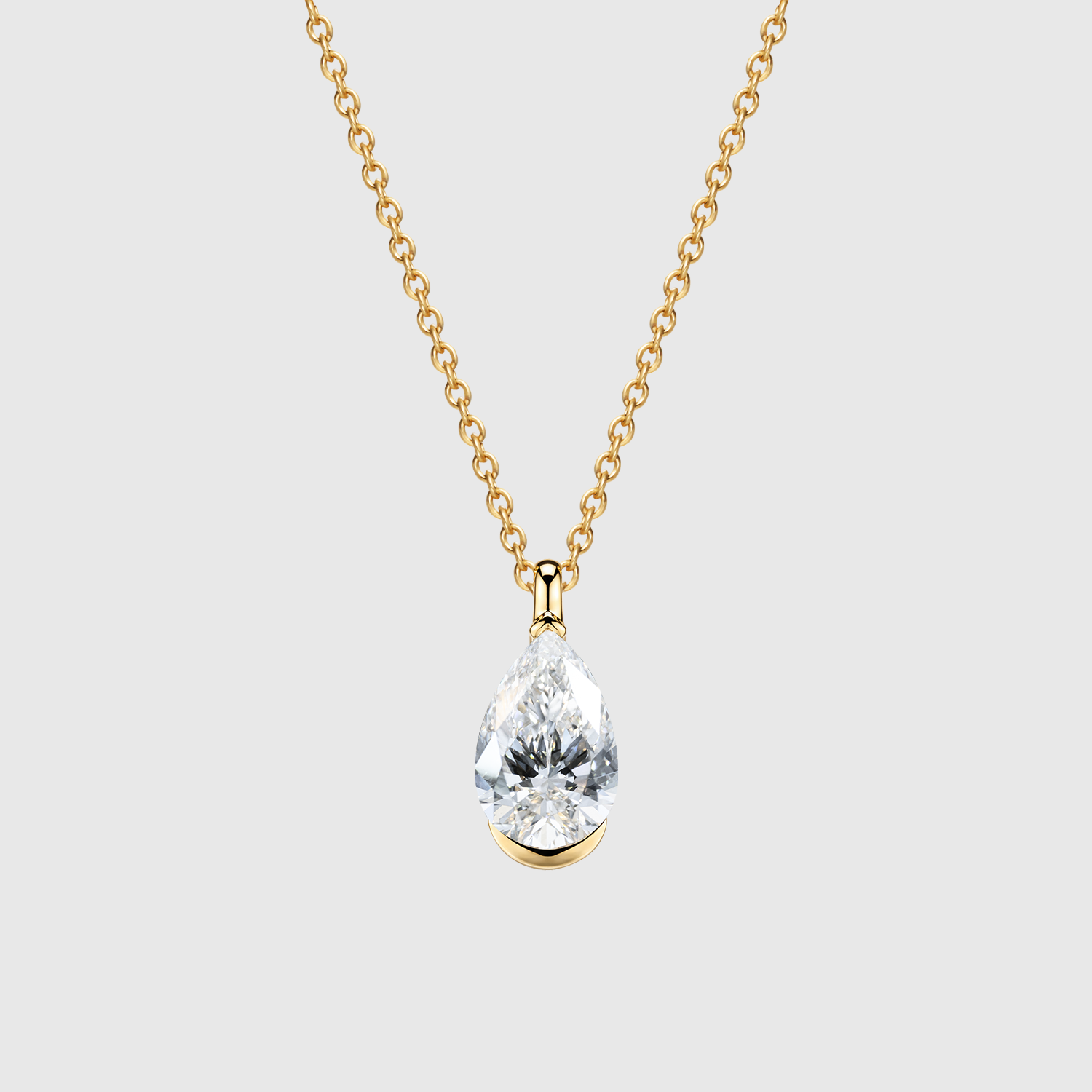 Pear-cut diamond pendant in yellow gold displayed on a matching fine chain.