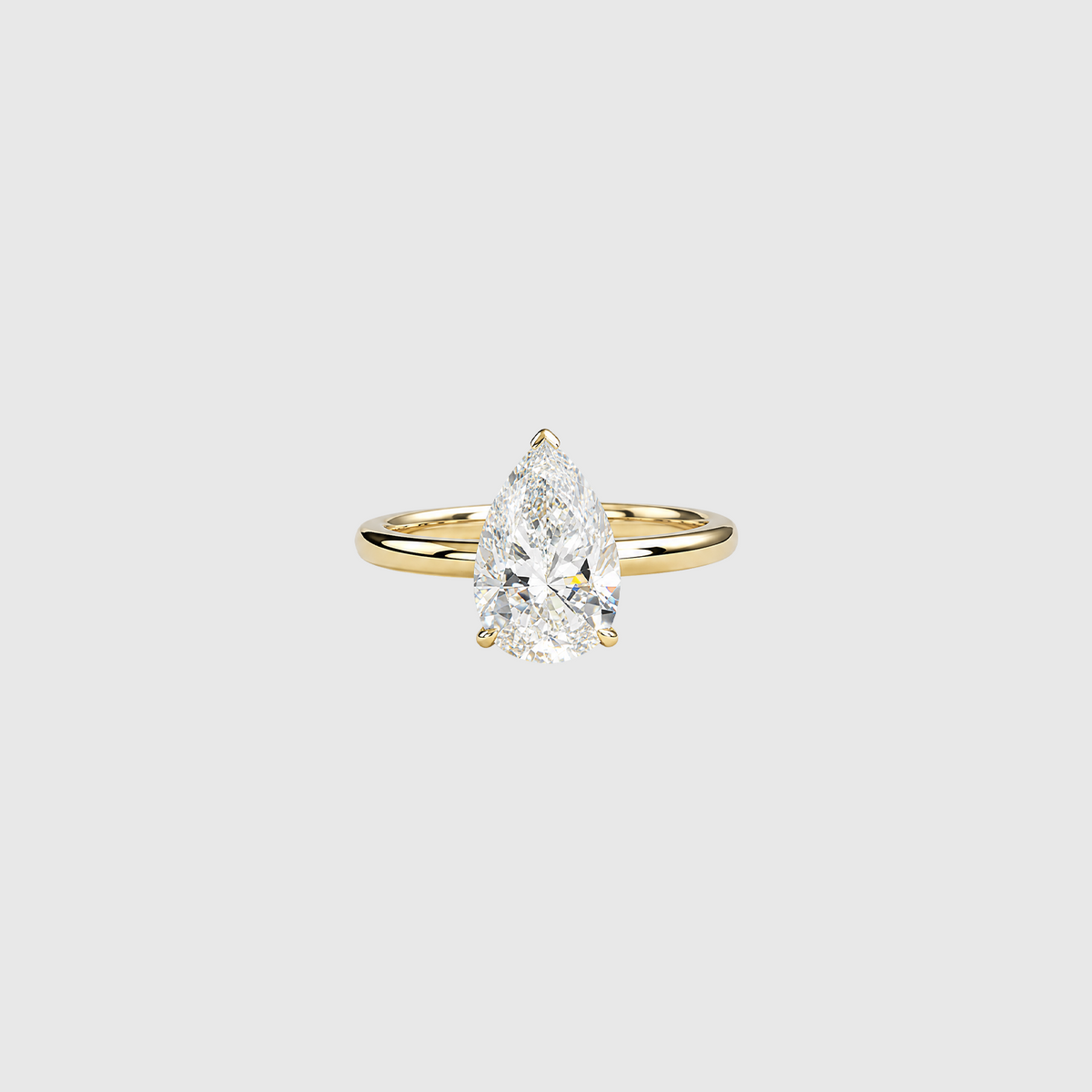 Pear-shaped lab-grown diamond solitaire engagement ring in yellow gold, front view.