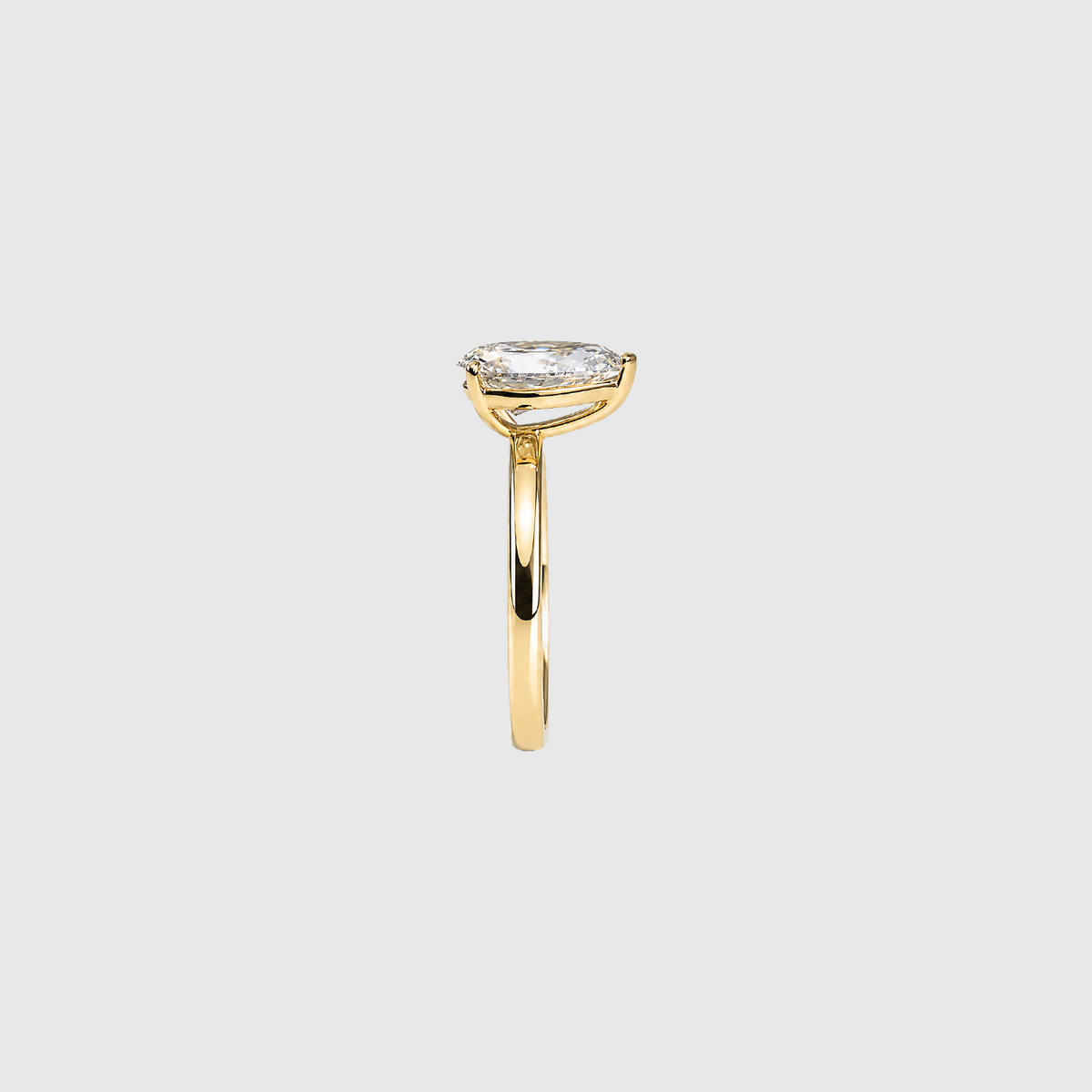 Pear-shaped lab-grown diamond solitaire engagement ring in yellow gold, side view.