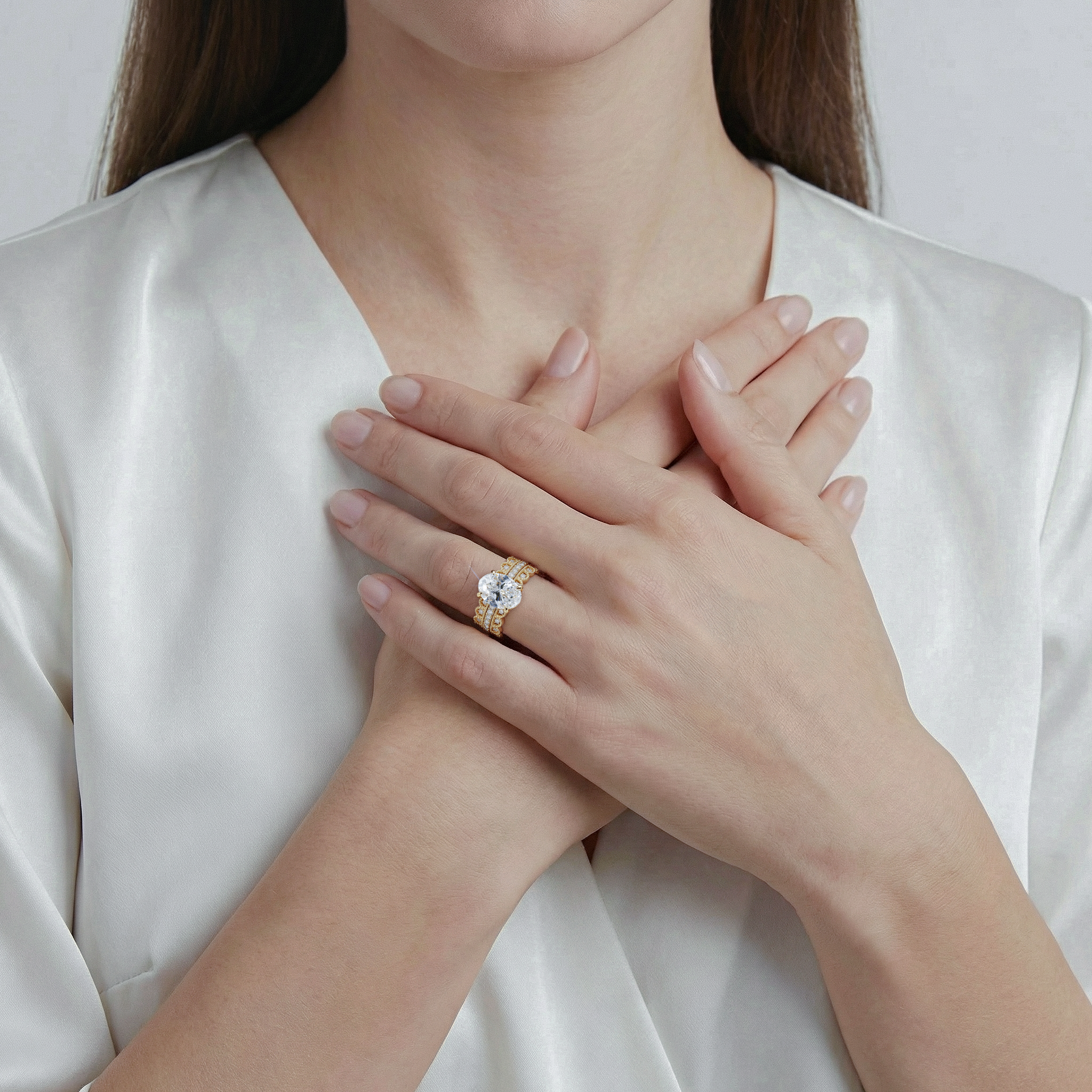 Woman wearing a gold ring with a diamond on a plain background