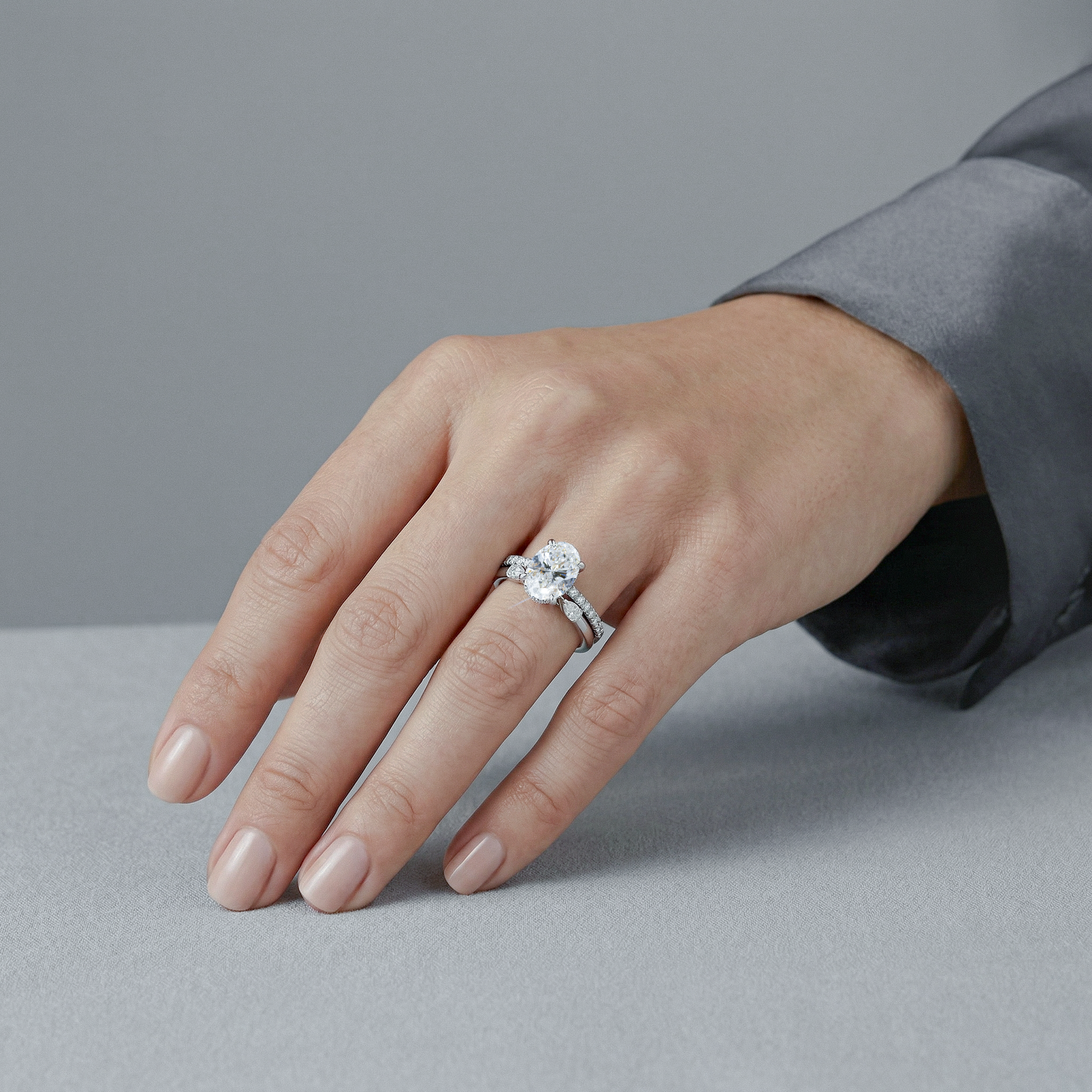 hand wearing a oval diamond ring set 