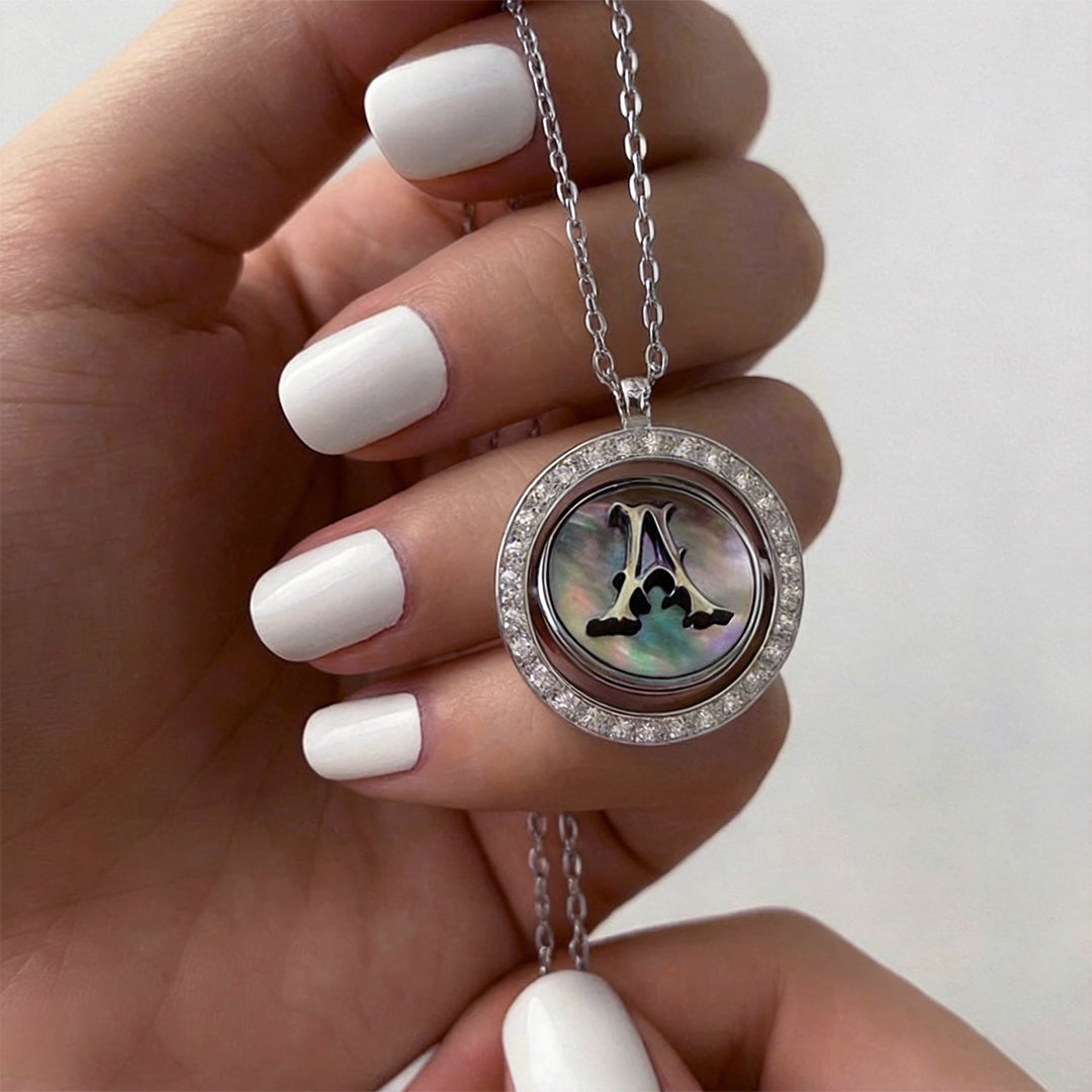 Reversible personalized initial diamond necklace with a black mother-of-pearl background, shown on a 925 sterling silver chain.